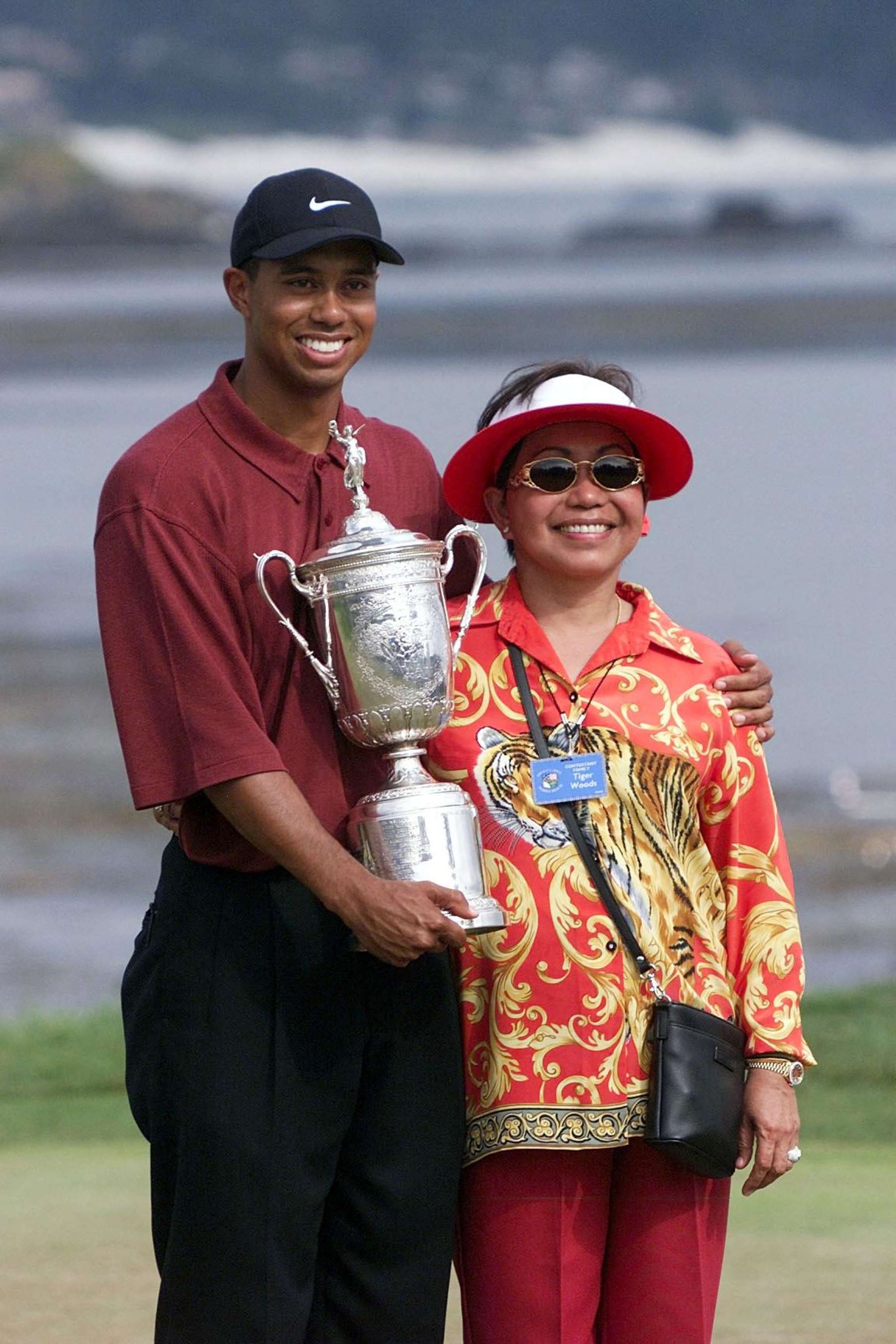 Tiger Woods poses with his mother, Kultida while holding his U.S. Open Championship trophy after winning the tournament at Pebble Beach in California 18 June, 2000. Woods won with a score of 12-under-par. AFP PHOTO/Mike FIALA (Photo by Mike FIALA / AFP) (Photo by MIKE FIALA/AFP via Getty Images) Tiger Woods poses with his mother, Kultida while holding his U.S. Open Championship trophy after winning the tournament at Pebble Beach in California 18 June, 2000. Woods won with a score of 12-under-par. AFP PHOTO/Mike FIALA (Photo by Mike FIALA / AFP) (Photo by MIKE FIALA/AFP via Getty Images)