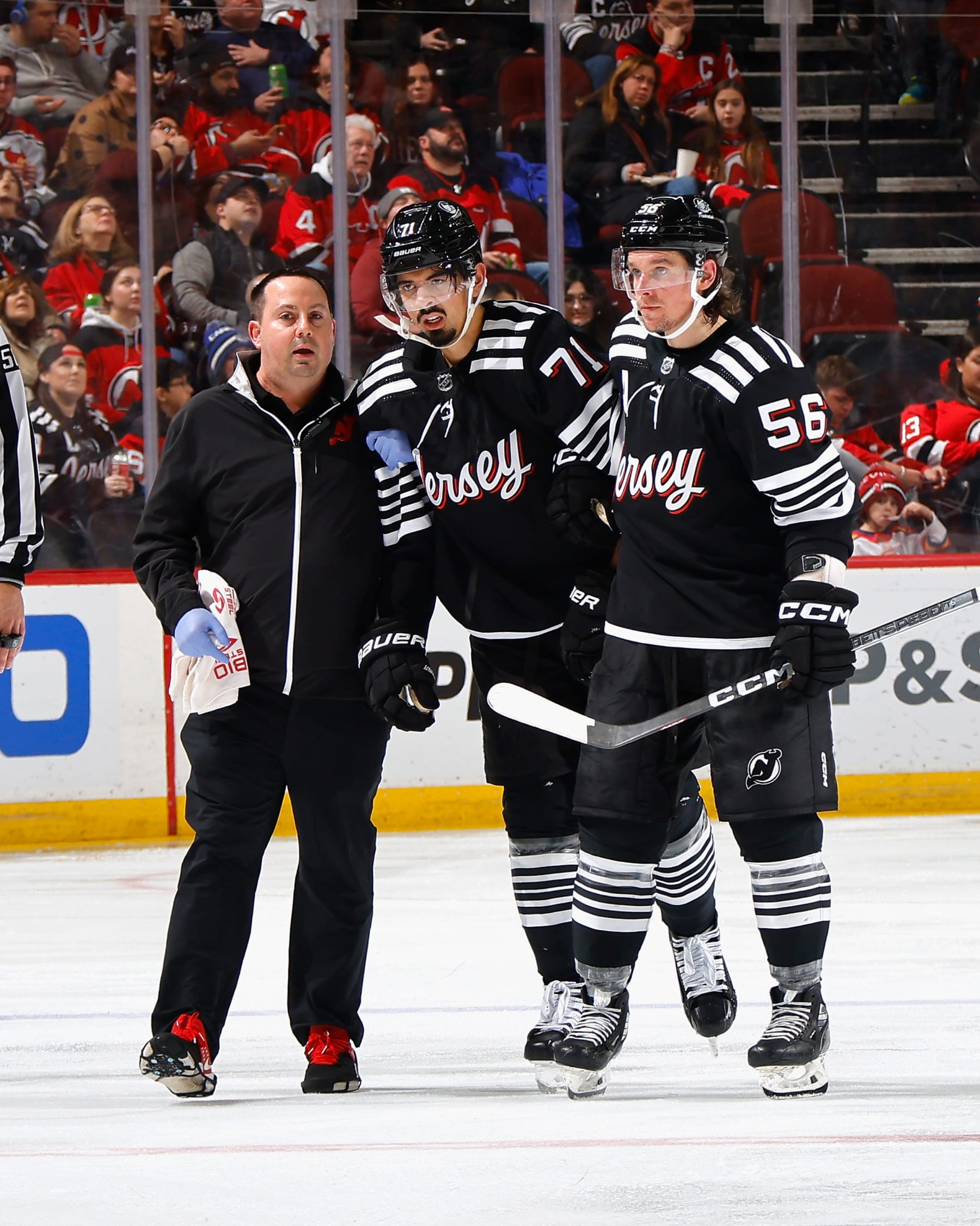 Jonas Siegenthaler is helped off the nice after suffering an injury for the Devils.