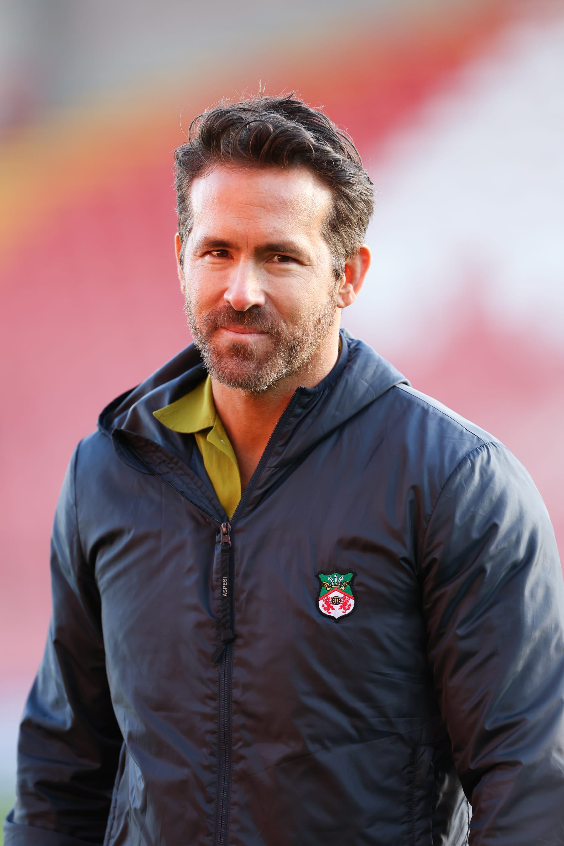 WREXHAM, WALES - MARCH 25: Wrexham co-owner Ryan Reynolds wearing a Wrexham jacket during the Vanarama National League match between Wrexham and York City at the Racecourse Ground on March 25, 2023 in Wrexham, Wales. (Photo by Matthew Ashton - AMA/Getty Images)