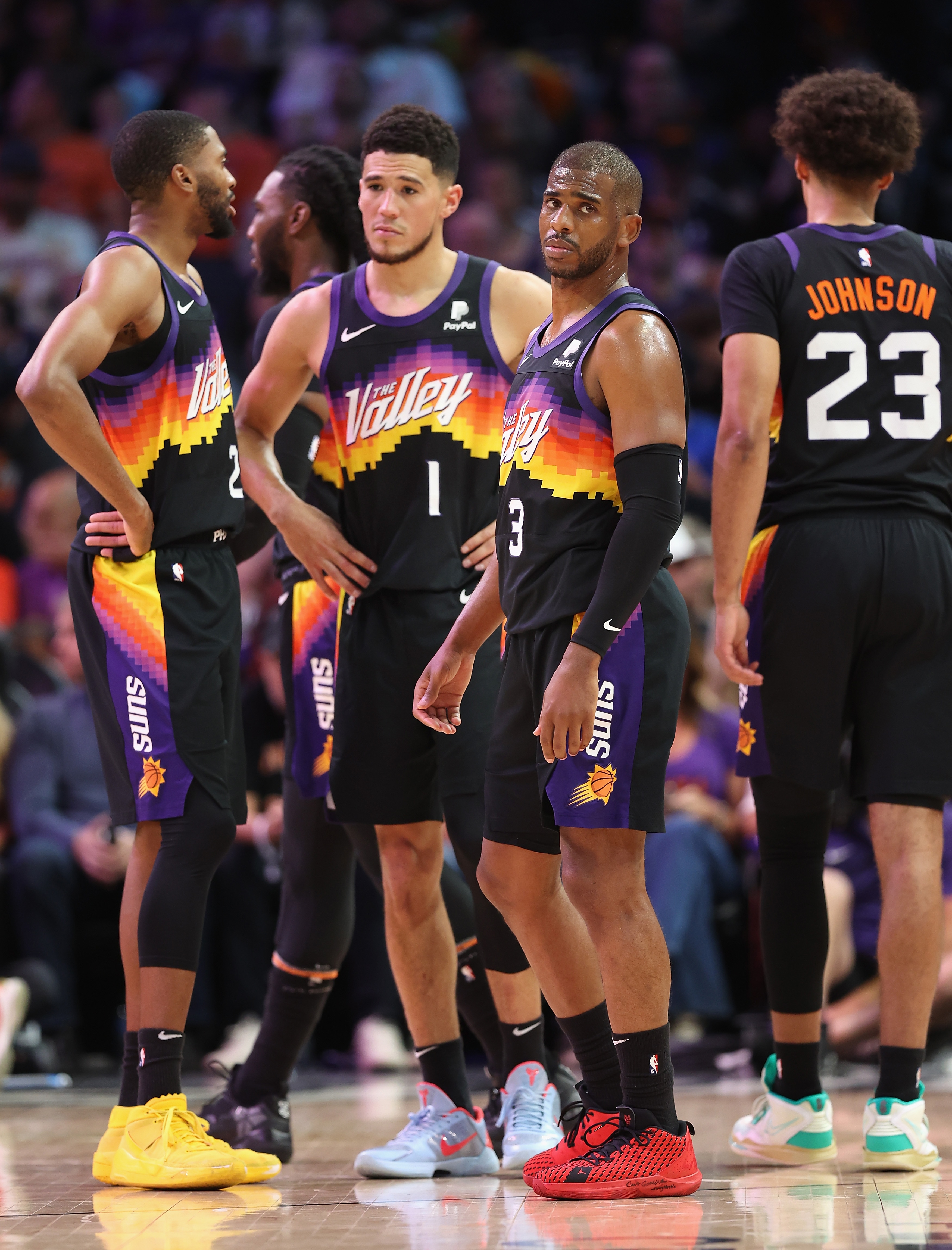 PHOENIX, ARIZONA - MAY 15: Chris Paul #3 of the Phoenix Suns stands on the court with Mikal Bridges #25, Devin Booker #1 and Cameron Johnson #23 during the first half of Game Seven of the Western Conference Second Round NBA Playoffs at Footprint Center on May 15, 2022 in Phoenix, Arizona. The Mavericks defeated the Suns 123-90. NOTE TO USER: User expressly acknowledges and agrees that, by downloading and or using this photograph, User is consenting to the terms and conditions of the Getty Images License Agreement. (Photo by Christian Petersen/Getty Images)
