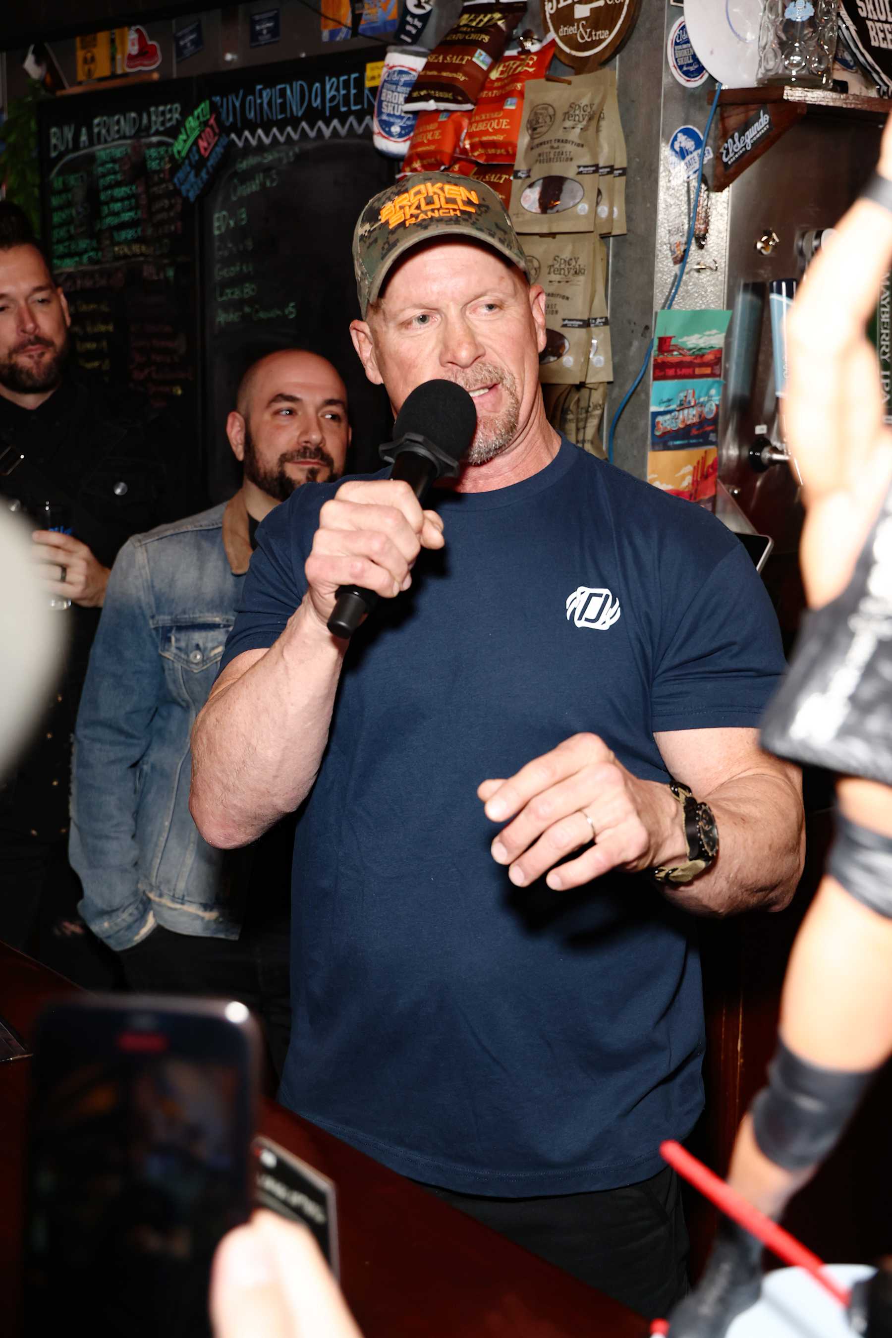 EL SEGUNDO, CALIFORNIA - MARCH 16: "Stone Cold" Steve Austin (C) speaks during WWE 2K23 Launch Event at El Segundo Brewing Company on March 16, 2023 in El Segundo, California. (Photo by Joe Scarnici/Getty Images for 2K )