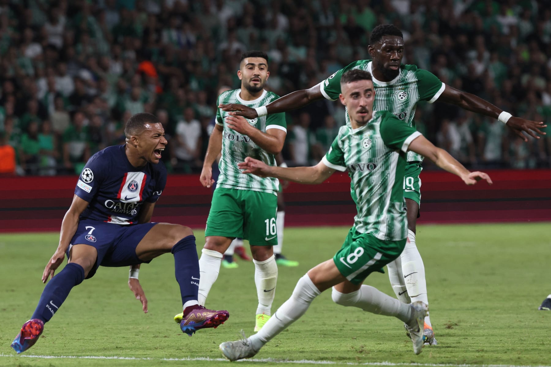 Paris Saint-Germain's French forward Kylian Mbappe (L) reacts after a challenge by Maccabi Haifa's French defender Dylan Batubinsika (R) during the UEFA Champions League group H football match between Israel's Maccabi Haifa and France's Paris Saint-Germain (PSG) at the Sammy Ofer stadium in the city of Haifa on September 14, 2022. (Photo by JACK GUEZ / AFP) (Photo by JACK GUEZ/AFP via Getty Images)