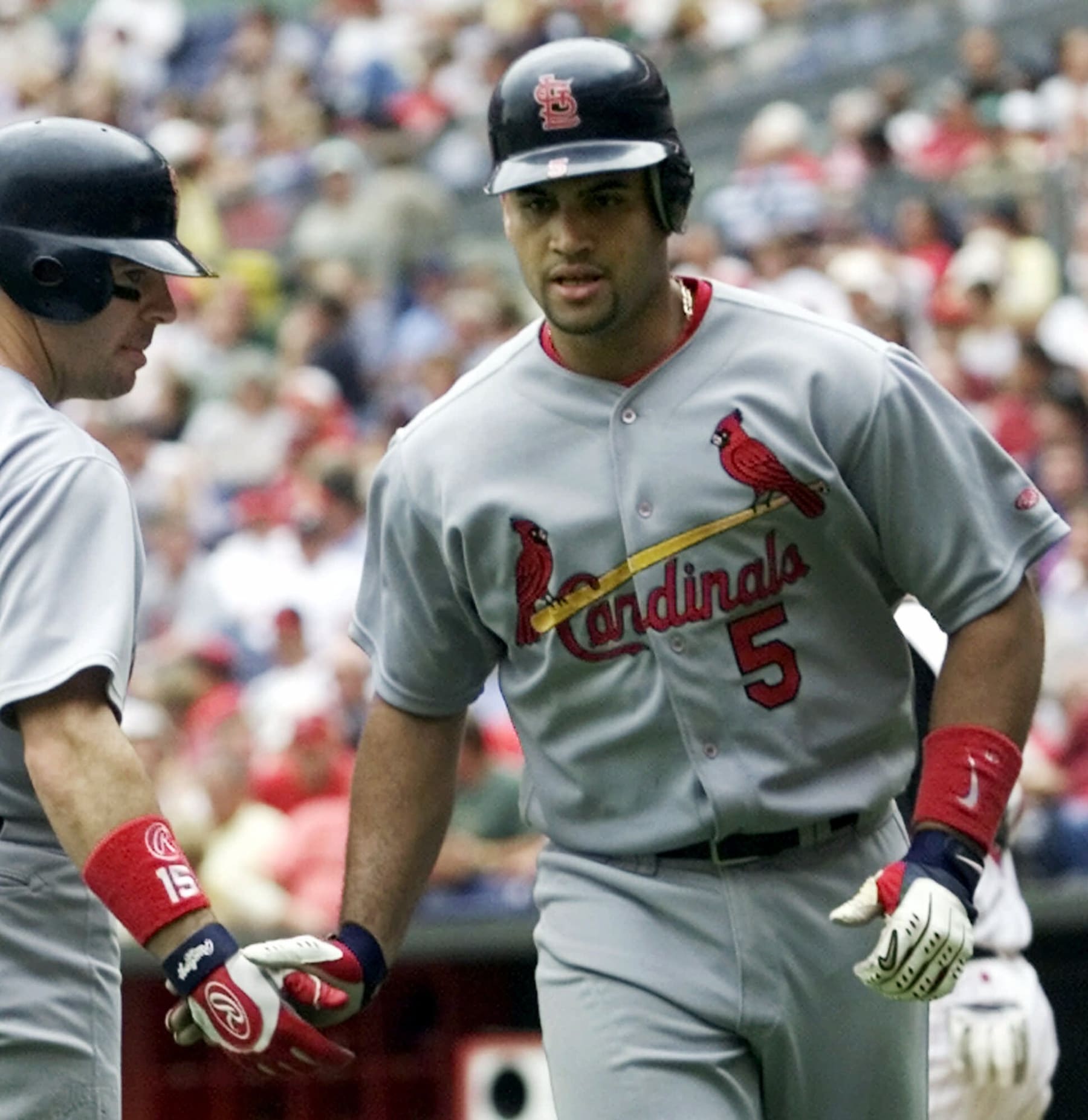 St. Louis Cardinals' Albert Pujols (5) is congratulated by Jim Edmonds (15) after Pujols hit a solo home run against the Cincinnati Reds, in the sixth inning Thursday, Aug. 23, 2001, in Cincinnati. Pujols became the 22nd player in major league history to hit 30 home runs in his rookie season. Cincinnati won 12-2. (AP Photo/Al Behrman)