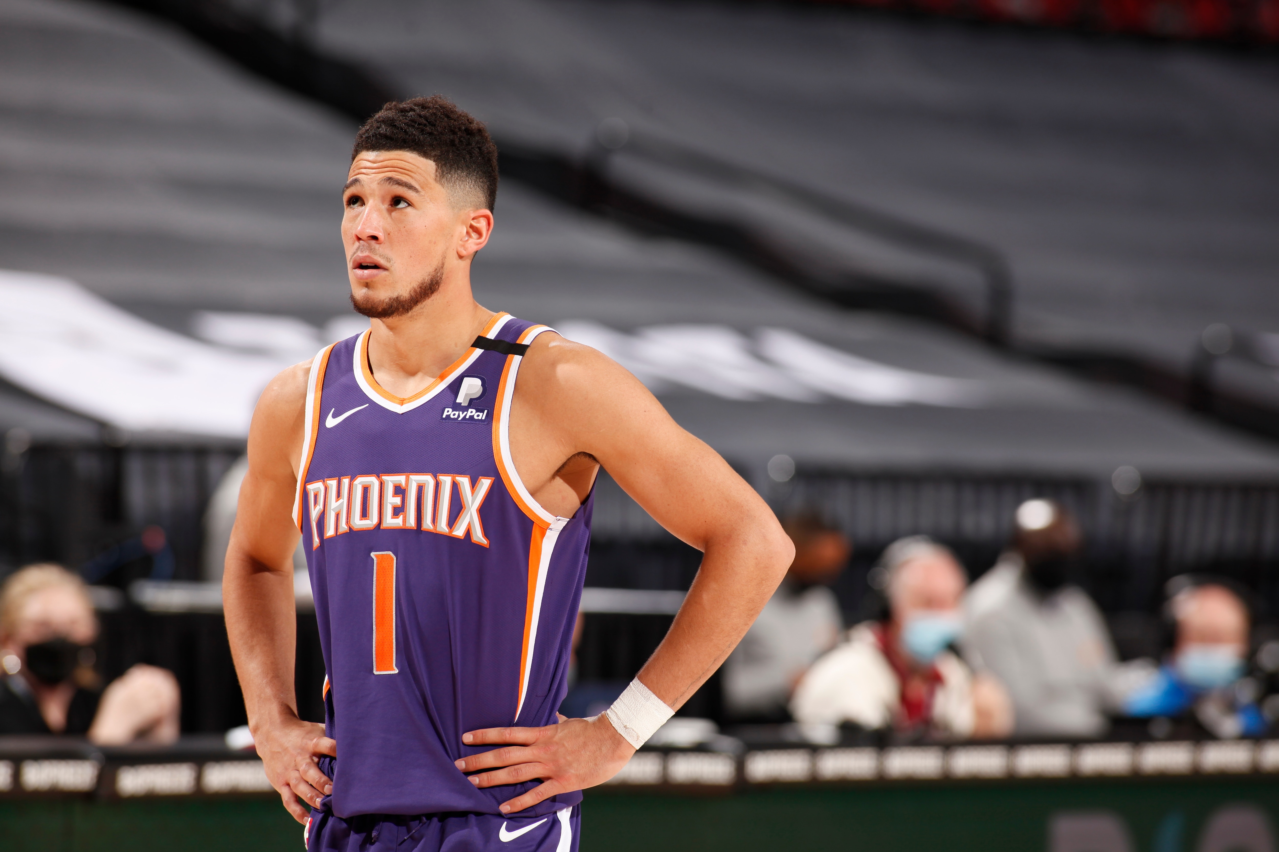 PORTLAND, OR - MARCH 11: Devin Booker #1 of the Phoenix Suns looks on during the game against the Portland Trail Blazers on March 11, 2021 at the Moda Center Arena in Portland, Oregon. NOTE TO USER: User expressly acknowledges and agrees that, by downloading and or using this photograph, user is consenting to the terms and conditions of the Getty Images License Agreement. Mandatory Copyright Notice: Copyright 2021 NBAE (Photo by Cameron Browne/NBAE via Getty Images)