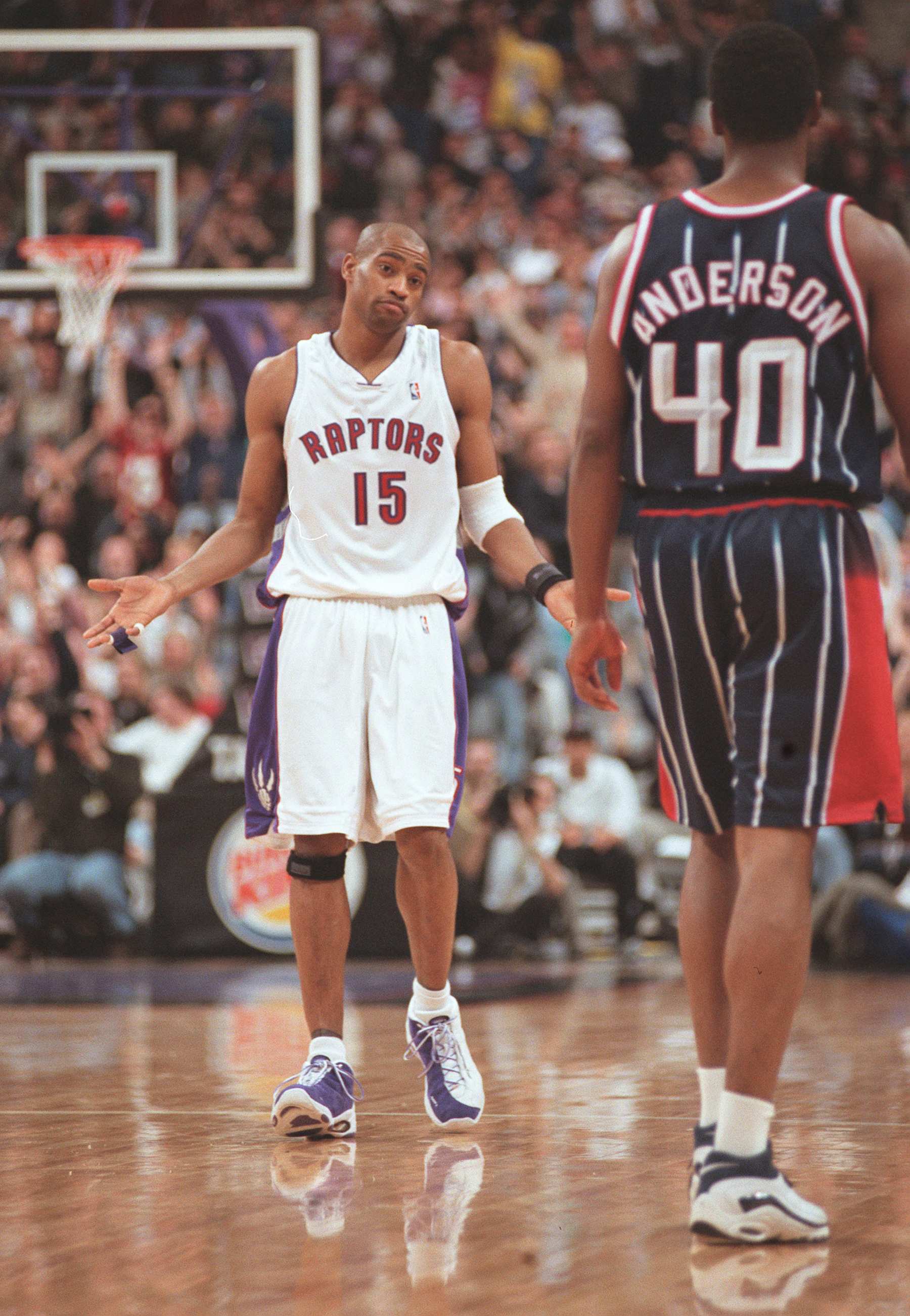 Toronto Raptors guard Vince Carter (15) shrugs his shoulders at Houston Rockets forward Shandon Anderson (Right) after scoring the game winning dunk with less than two seconds to go in fourth quarter NBA action in Toronto on Sunday March 19, 2000. Carter scored 37 points to lead the Raptors to a 100-98 win. (Photo by Rick Madonik/Toronto Star via Getty Images)