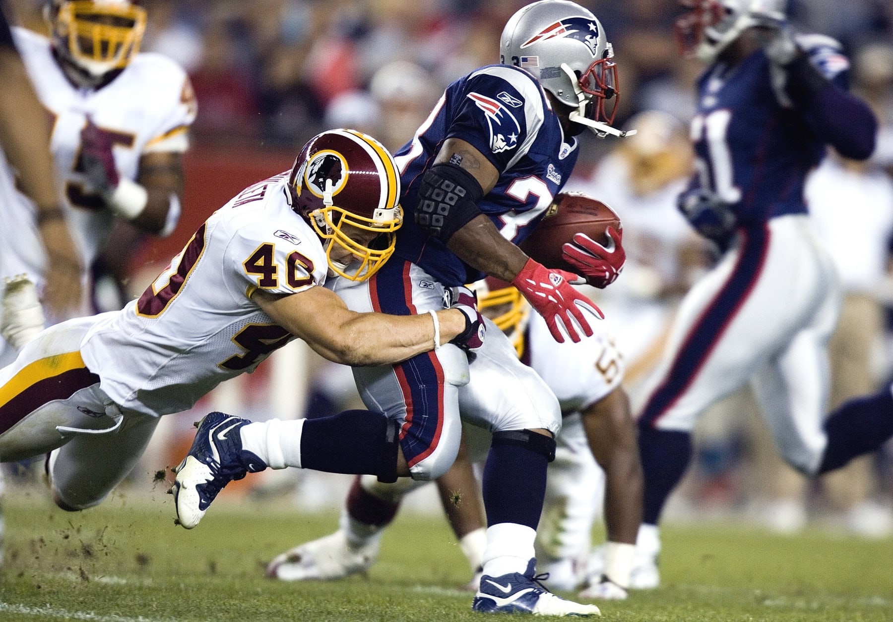 FOXBOROUGH, MA - AUGUST 26: Washington Redskins Adam Archuleta #40 tackles New England patriots Kevin Faulk #33 during the first half of a preseason game at Gillette Stadium August 25, 2006 in Foxborough, Massachusetts. The Patriots lead 20 to 0 at the end of the first half. (Photo by Brendan Smialowski/Getty Images)