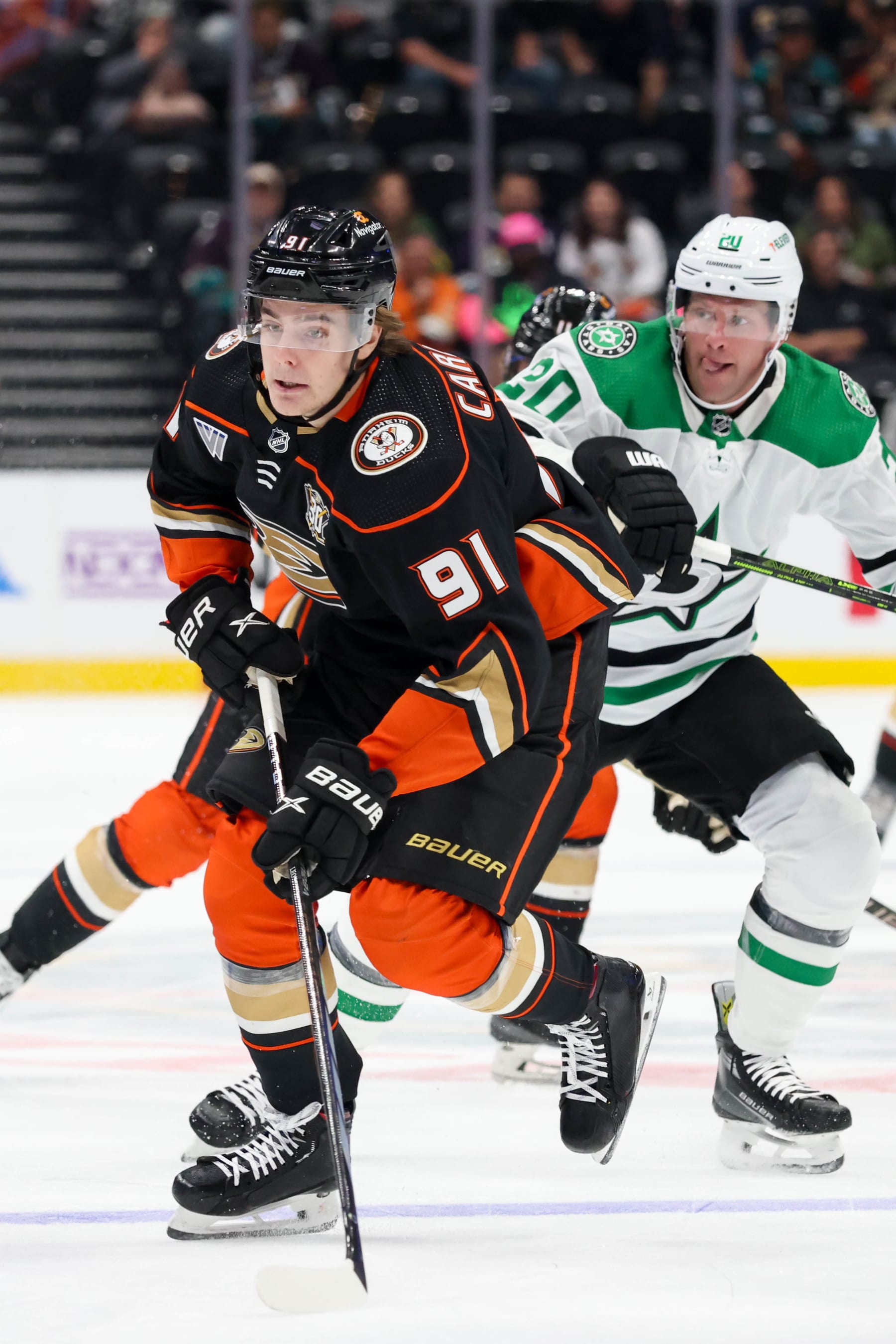 ANAHEIM, CA - OCTOBER 19:  Leo Carlsson #91 of the Anaheim Ducks skates with the puck with pressure from Ryan Suter #20 of the Dallas Stars during the first period Honda Center on October 19, 2023 in Anaheim, California. (Photo by Debora Robinson/NHLI via Getty Images)