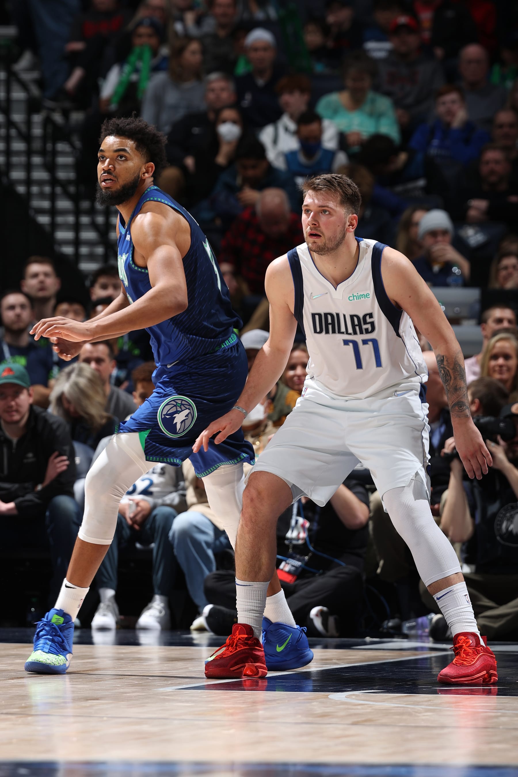 MINNEAPOLIS, MN - MARCH 25: Karl-Anthony Towns #32 of the Minnesota Timberwolves and Luka Doncic #77 of the Dallas Mavericks looks on during the game on March 25, 2022 at Target Center in Minneapolis, Minnesota. NOTE TO USER: User expressly acknowledges and agrees that, by downloading and or using this Photograph, user is consenting to the terms and conditions of the Getty Images License Agreement. Mandatory Copyright Notice: Copyright 2022 NBAE (Photo by David Sherman/NBAE via Getty Images)