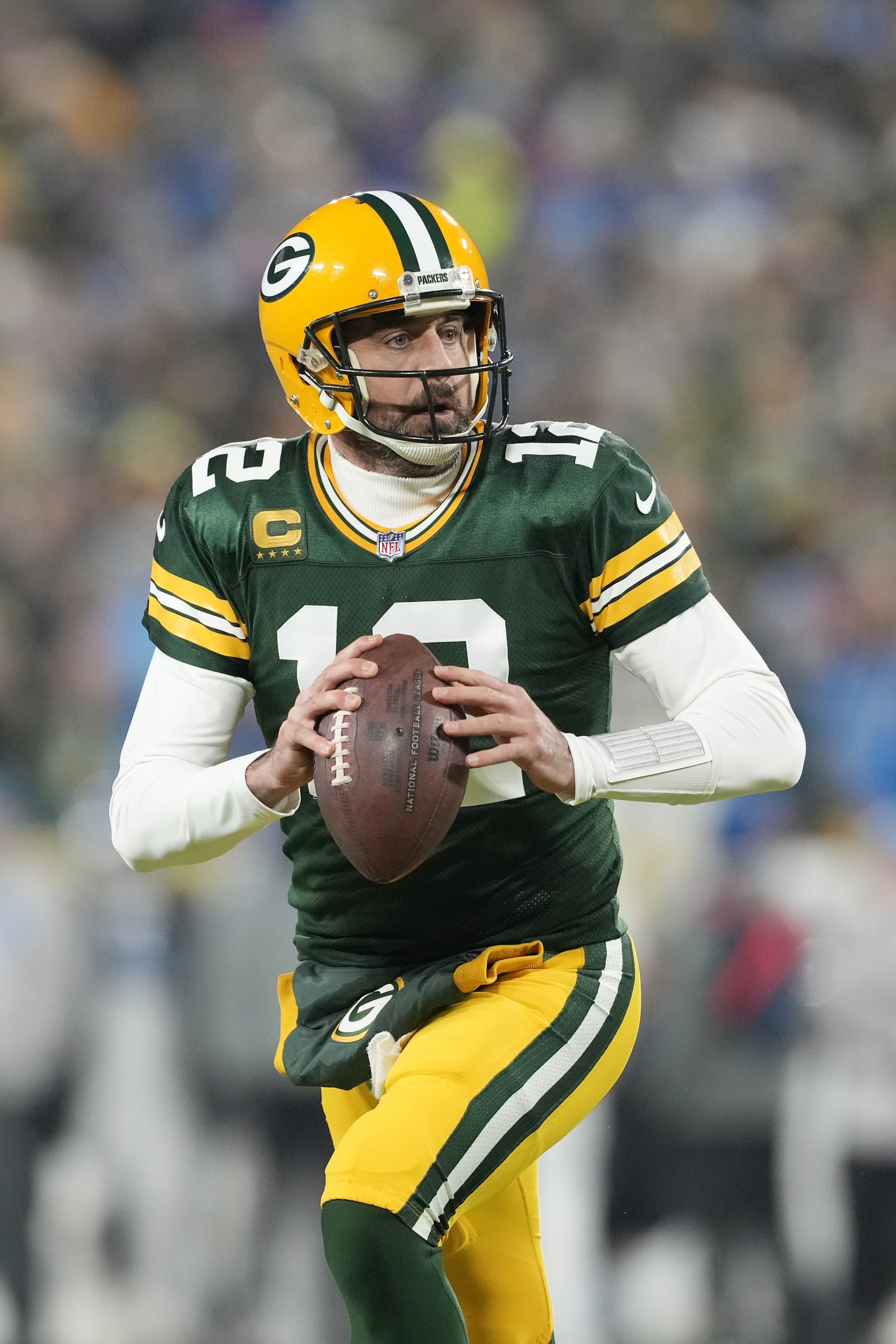 GREEN BAY, WISCONSIN - JANUARY 08: Aaron Rodgers #12 of the Green Bay Packers scrambles with the ball against the Detroit Lions in the first half at Lambeau Field on January 08, 2023 in Green Bay, Wisconsin. (Photo by Patrick McDermott/Getty Images)
