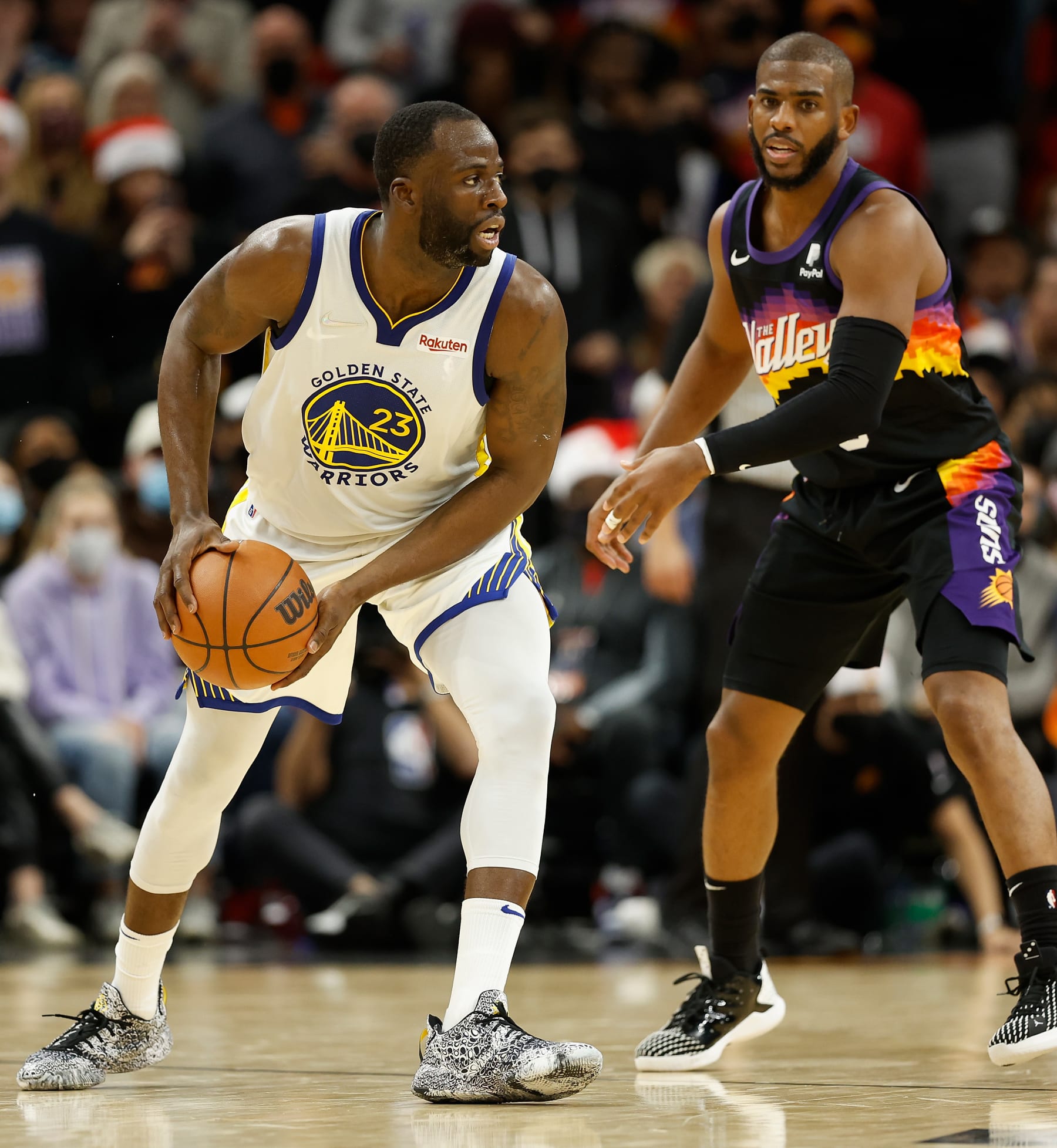 PHOENIX, ARIZONA - DECEMBER 25:  Draymond Green #23 of the Golden State Warriors handles the ball against Chris Paul #3 of the Phoenix Suns during the second half of NBA game at Footprint Center on December 25, 2021 in Phoenix, Arizona.  The Warriors defeated the Suns 116-107.  NOTE TO USER: User expressly acknowledges and agrees that, by downloading and or using this photograph, User is consenting to the terms and conditions of the Getty Images License Agreement.  (Photo by Christian Petersen/Getty Images)
