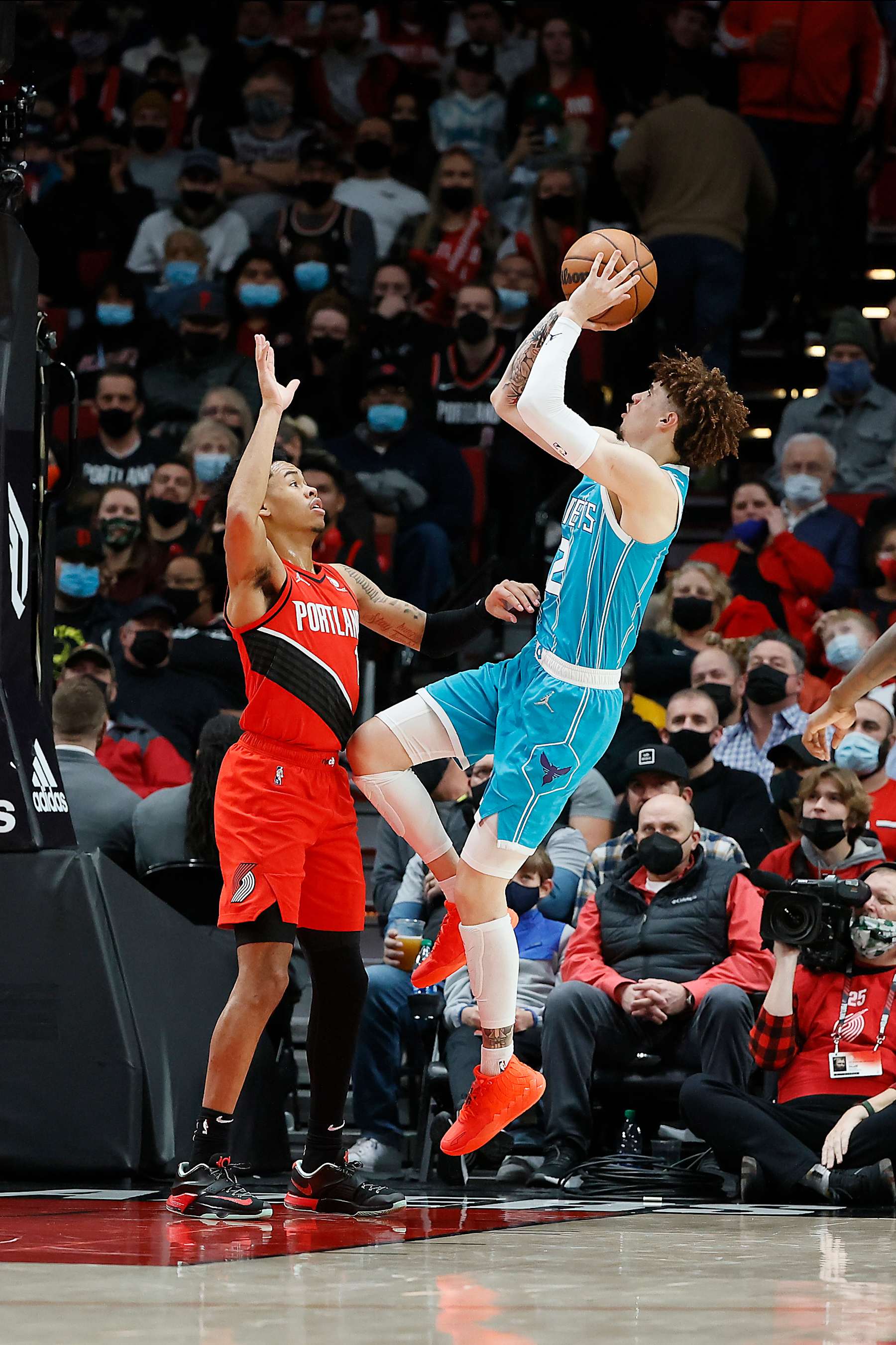 PORTLAND, OREGON - DECEMBER 17: LaMelo Ball # 2 of the Charlotte Hornets shoots the ball over Anfernee Simons # 1 of the Portland Trail Blazers during the second half at Moda Center on December 17, 2021 in Portland, Oregon. NOTE TO USER: User expressly acknowledges and agrees that, by downloading and or using this photograph, User is consenting to the terms and conditions of the Getty Images License Agreement. (Photo by Soobum Im/Getty Images)