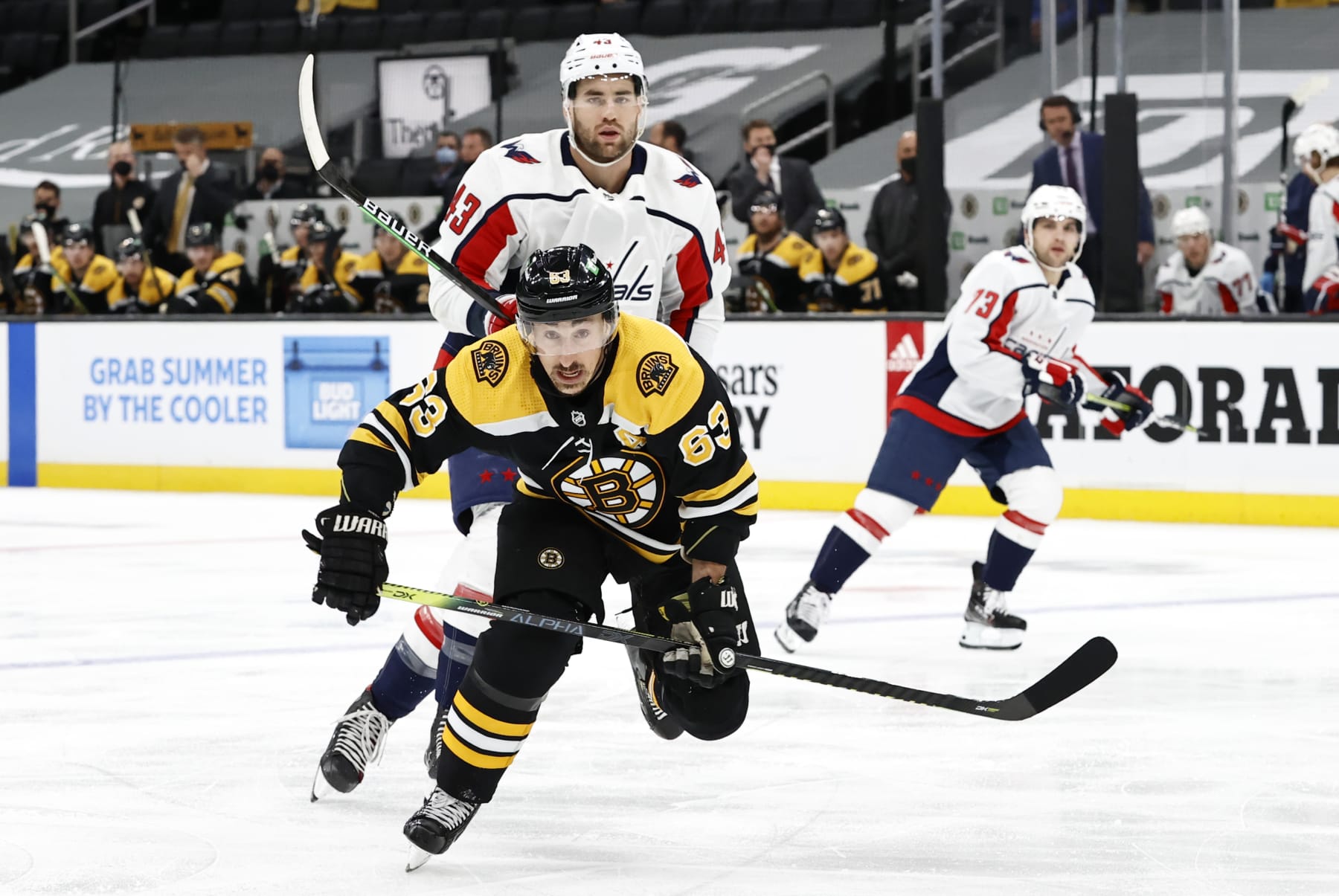 BOSTON, MA - MAY 21: Boston Bruins left wing Brad Marchand (63) chases down the puck shadowed by Washington Capitals right wing Tom Wilson (43) during Game 4 of the NHL Stanley Cup Playoffs First Round between the Boston Bruins and the Washington Capitals on May 21, 2021, at TD Garden in Boston, Massachusetts. (Photo by Fred Kfoury III/Icon Sportswire via Getty Images)