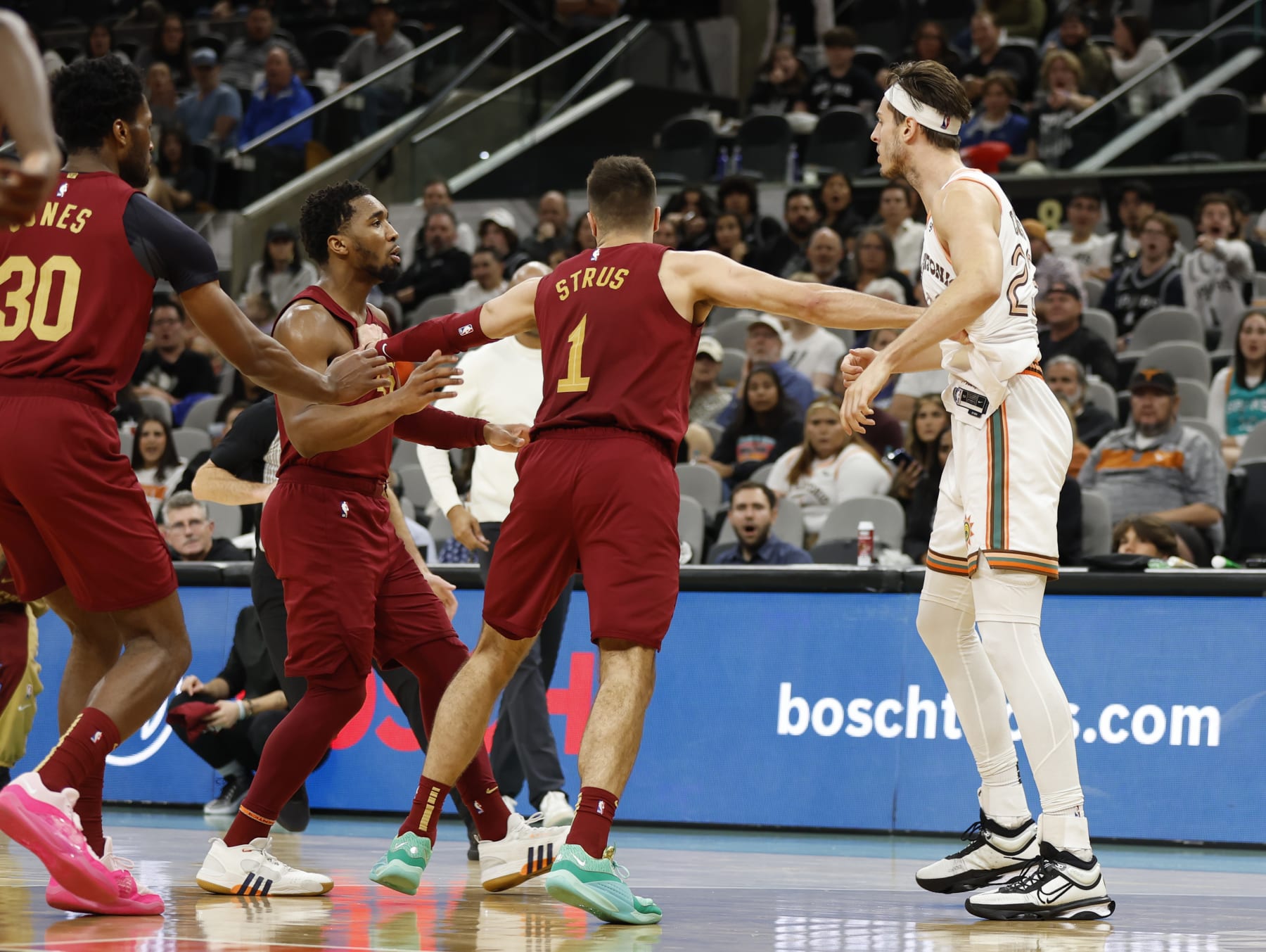 SAN ANTONIO, TX - FEBRUARY 03: Donovan Mitchell #45 of the Cleveland Cavaliers is restrained by Max Strus after he took a punch at Zach Collins #23 of the San Antonio Spurs of the Cleveland Cavaliers late in the second half at Frost Bank Center on February 3, 2024 in San Antonio, Texas. Both players were ejected. NOTE TO USER: User expressly acknowledges and agrees that, by downloading and or using this photograph, User is consenting to terms and conditions of the Getty Images License Agreement. (Photo by Ronald Cortes/Getty Images)