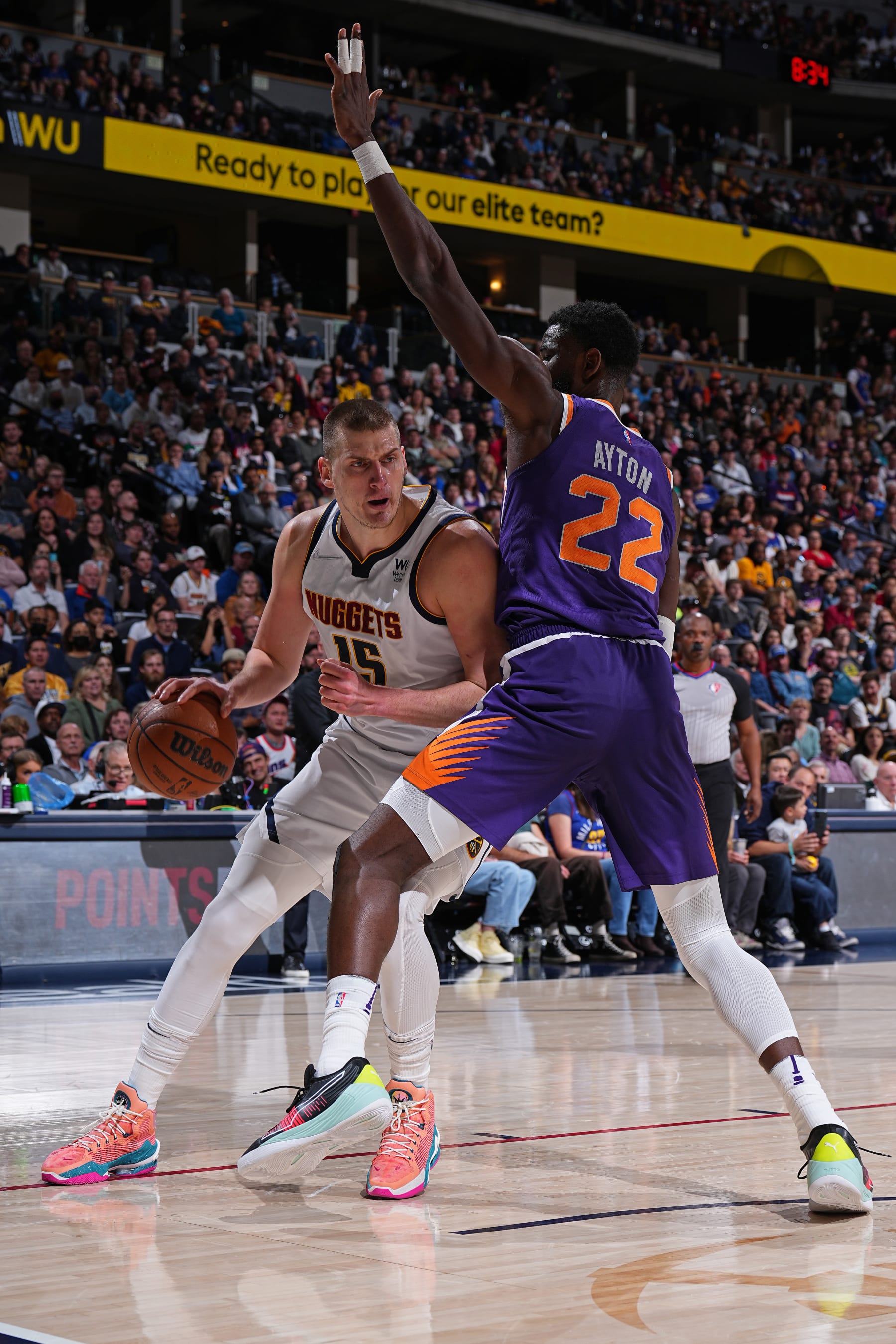DENVER, CO - MARCH 24: Deandre Ayton #22 of the Phoenix Suns plays defense on Nikola Jokic #15 of the Denver Nuggets during the game on March 24, 2022 at the Ball Arena in Denver, Colorado. NOTE TO USER: User expressly acknowledges and agrees that, by downloading and/or using this Photograph, user is consenting to the terms and conditions of the Getty Images License Agreement. Mandatory Copyright Notice: Copyright 2022 NBAE (Photo by Garrett Ellwood/NBAE via Getty Images)