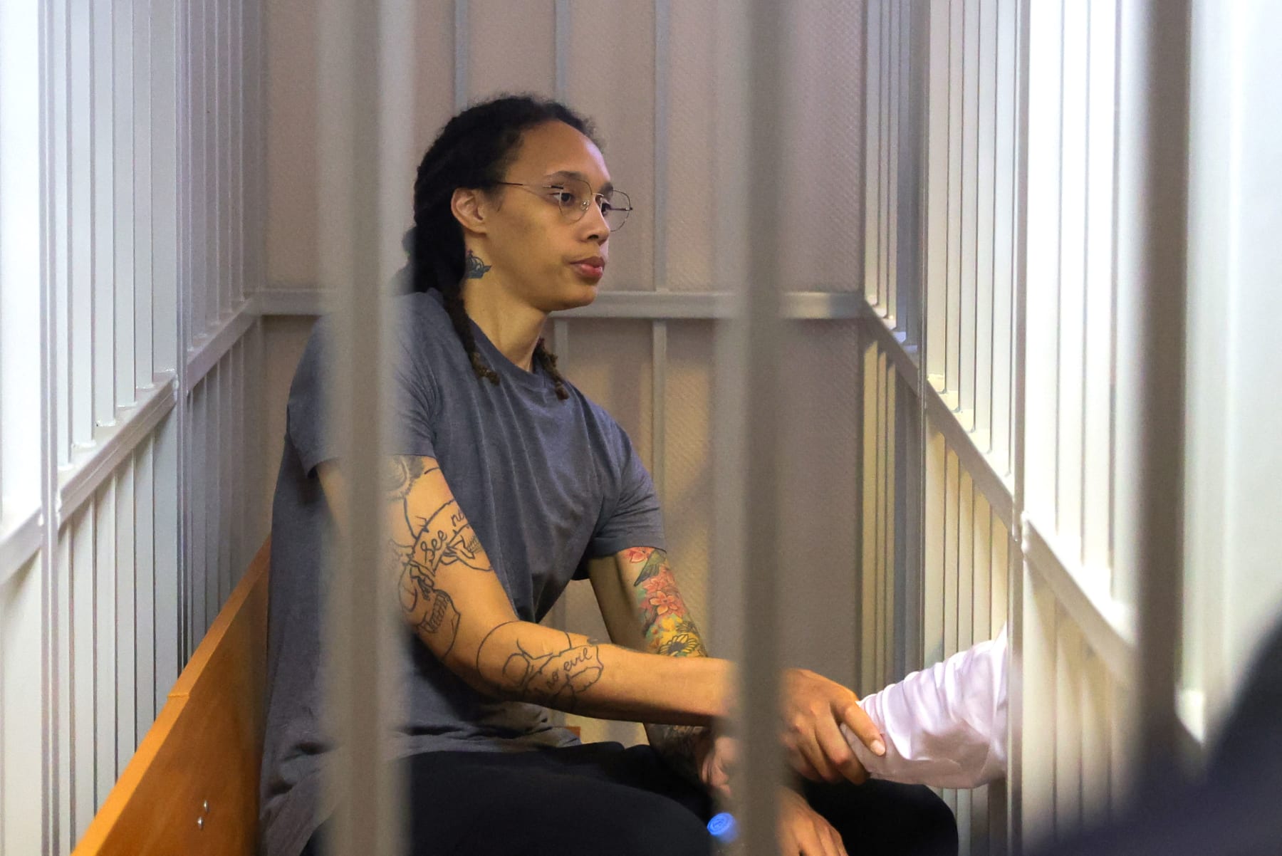 US Women's National Basketball Association (WNBA) basketball player Brittney Griner, who was detained at Moscow's Sheremetyevo airport and later charged with illegal possession of cannabis, sits inside a defendants' cage after the court's verdict during a hearing in Khimki outside Moscow, on August 4, 2022. - A Russian court found Griner guilty of smuggling and storing narcotics after prosecutors requested a sentence of nine and a half years in jail for the athlete. (Photo by EVGENIA NOVOZHENINA / POOL / AFP) (Photo by EVGENIA NOVOZHENINA/POOL/AFP via Getty Images)