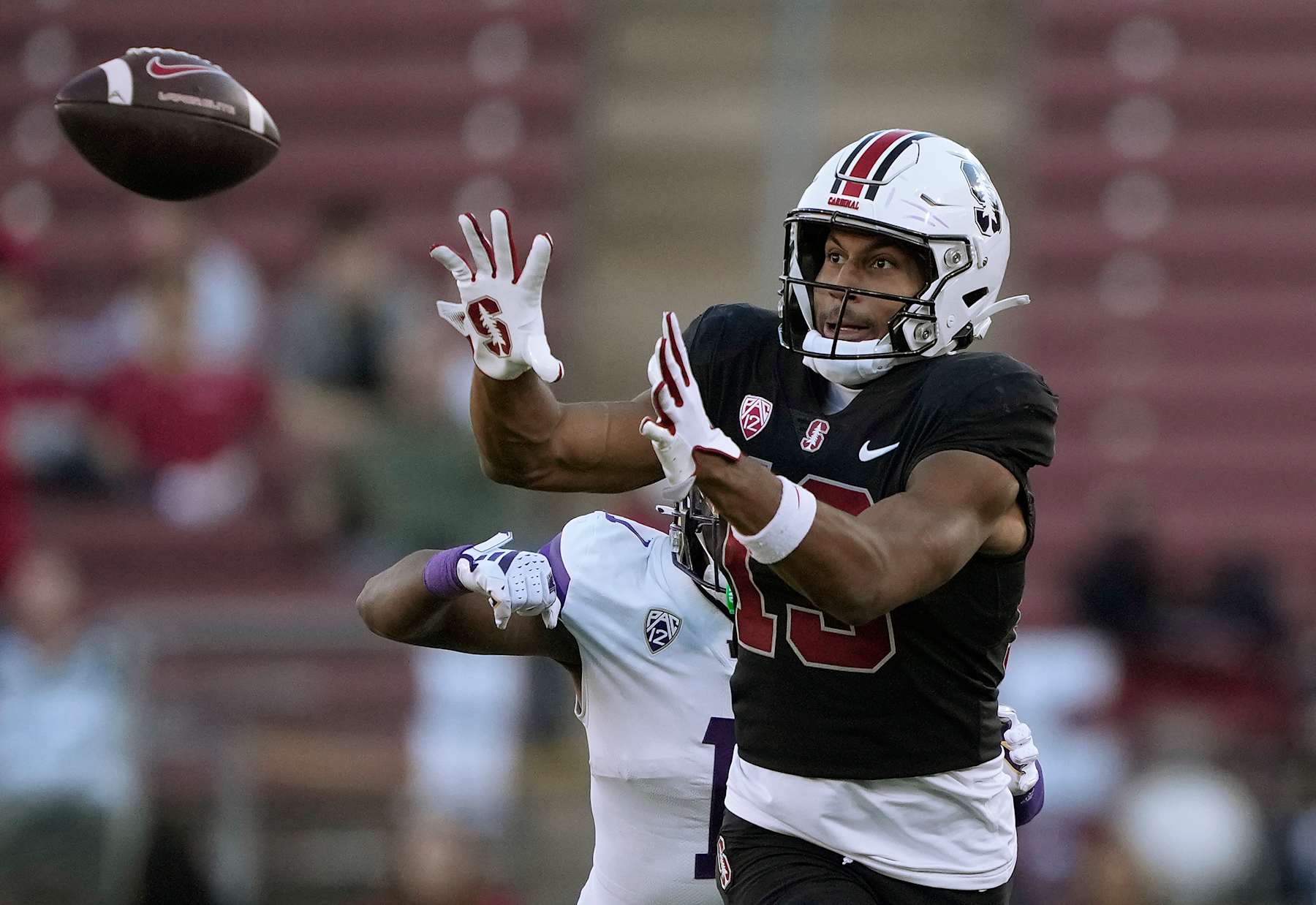 STANFORD, CALIFORNIA - OCTOBER 28: Elic Ayomanor #13 of the Stanford Cardinal catches a pass in front of Jabbar Muhammad #1 of the Washington Huskies during the second quarter at Stanford Stadium on October 28, 2023 in Stanford, California. (Photo by Thearon W. Henderson/Getty Images)