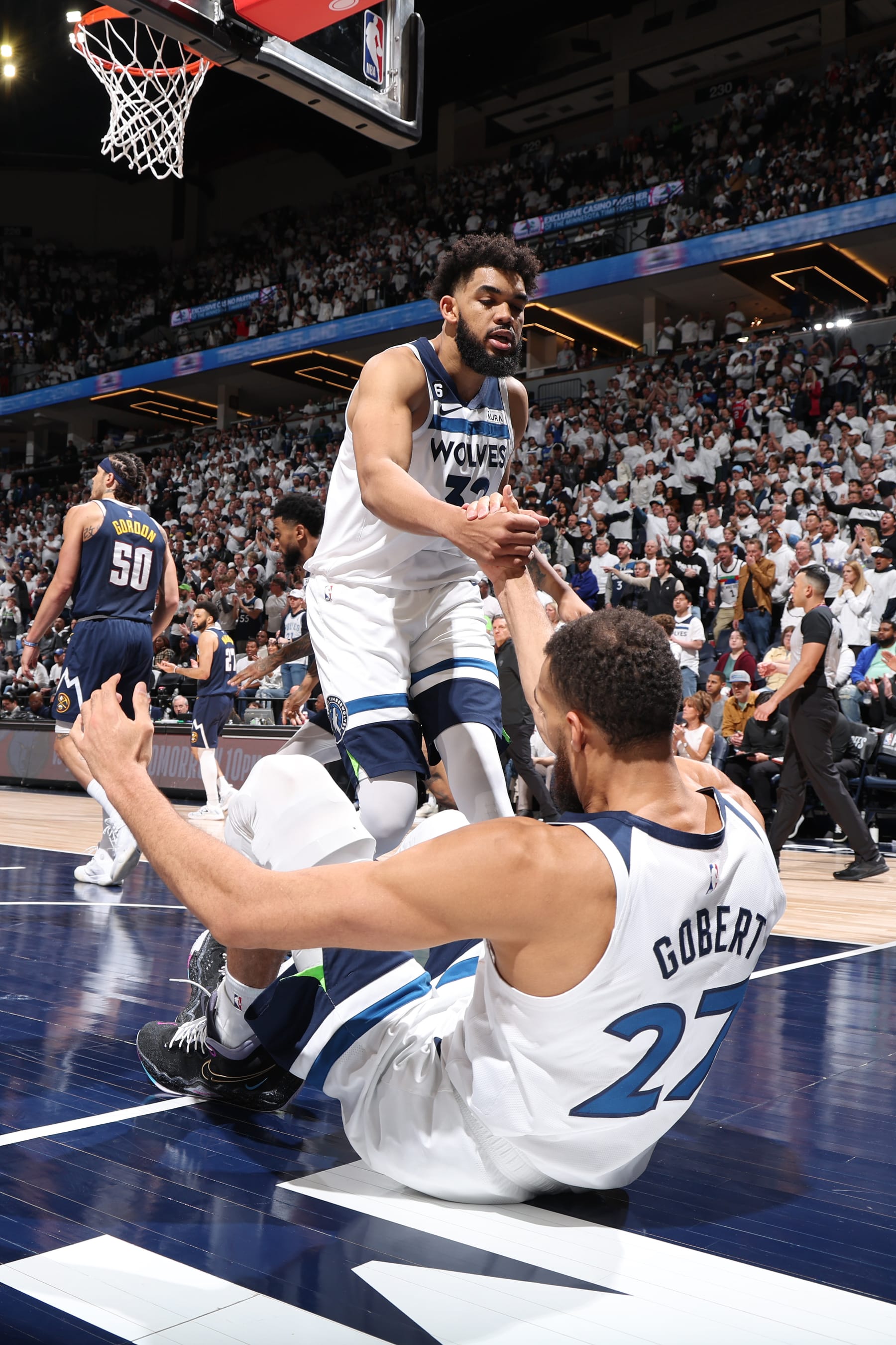 MINNEAPOLIS, MN - APRIL 23: Karl-Anthony Towns #32 helps up Rudy Gobert #27 of the Minnesota Timberwolves during Round 1 Game 4 of the 2023 NBA Playoffs against the Denver Nuggets on April 23, 2023 at Target Center in Minneapolis, Minnesota. NOTE TO USER: User expressly acknowledges and agrees that, by downloading and or using this Photograph, user is consenting to the terms and conditions of the Getty Images License Agreement. Mandatory Copyright Notice: Copyright 2023 NBAE (Photo by David Sherman/NBAE via Getty Images)
