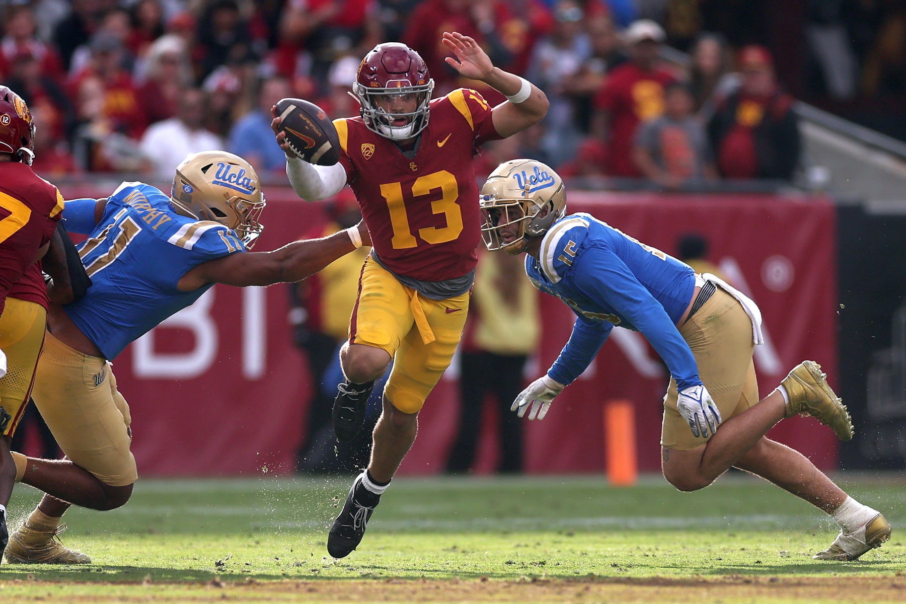 LOS ANGELES, CALIFORNIA - NOVEMBER 18: Gabriel Murphy #11 and Laiatu Latu #15 of the UCLA Bruins pressure Caleb Williams #13 of the USC Trojans from the pocket during the second half of a game at United Airlines Field at the Los Angeles Memorial Coliseum on November 18, 2023 in Los Angeles, California. (Photo by Sean M. Haffey/Getty Images)