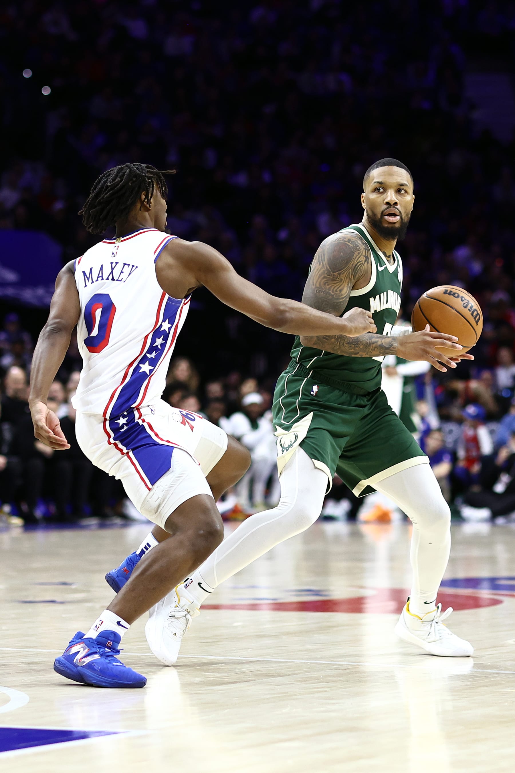 PHILADELPHIA, PENNSYLVANIA - FEBRUARY 25: Damian Lillard #0 of the Milwaukee Bucks looks to pass past Tyrese Maxey #0 of the Philadelphia 76ers during the third quarter at the Wells Fargo Center on February 25, 2024 in Philadelphia, Pennsylvania. (Photo by Tim Nwachukwu/Getty Images)