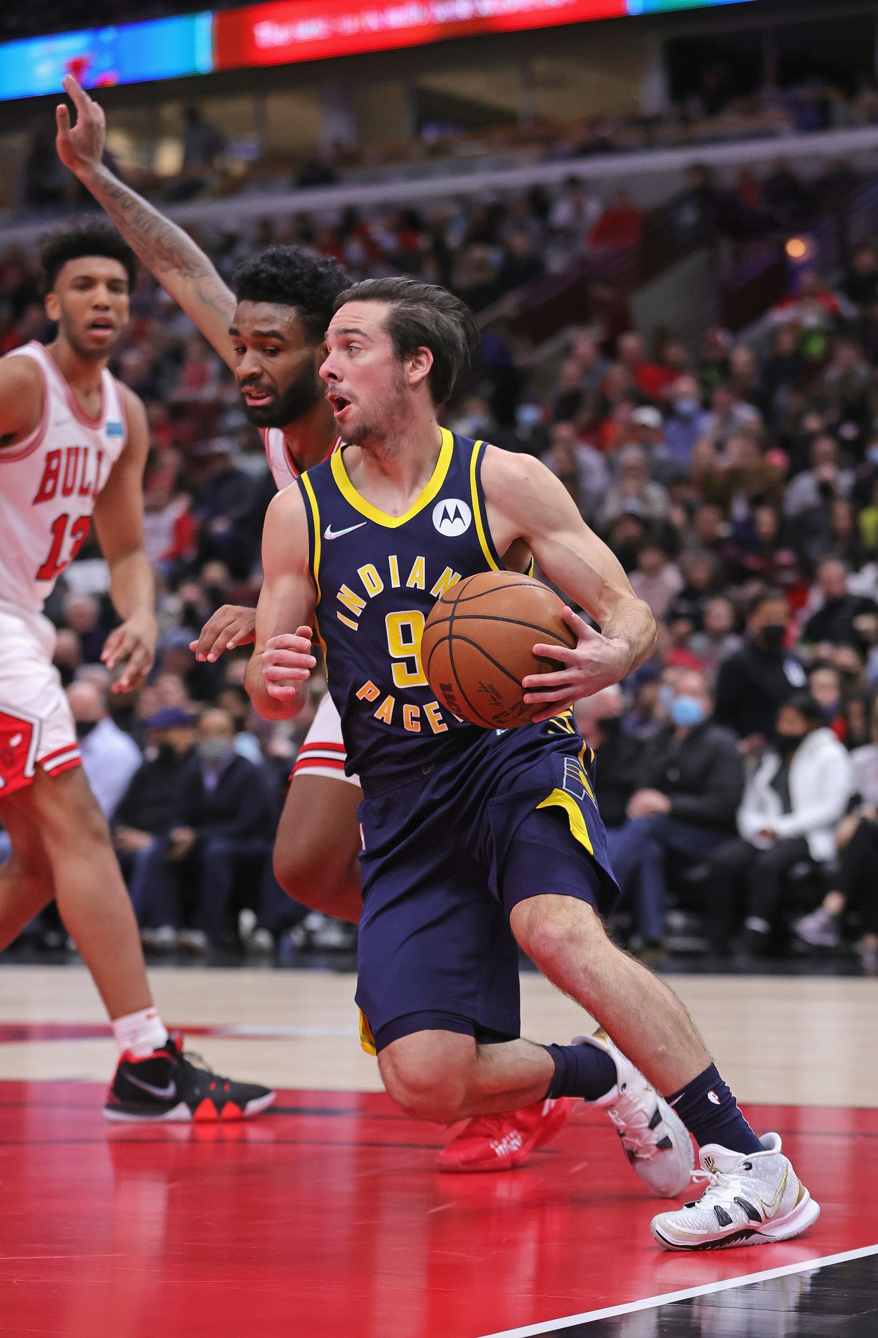 CHICAGO, ILLINOIS - NOVEMBER 22: T.J. McConnell #9 of the Indiana Pacers drives against Coby White #0 of the Chicago Bulls
 at the United Center on November 22, 2021 in Chicago, Illinois. The Pacers defeated the Bulls 109-77. NOTE TO USER: User expressly acknowledges and agrees that, by downloading and or using this photograph, User is consenting to the terms and conditions of the Getty Images License Agreement. (Photo by Jonathan Daniel/Getty Images)