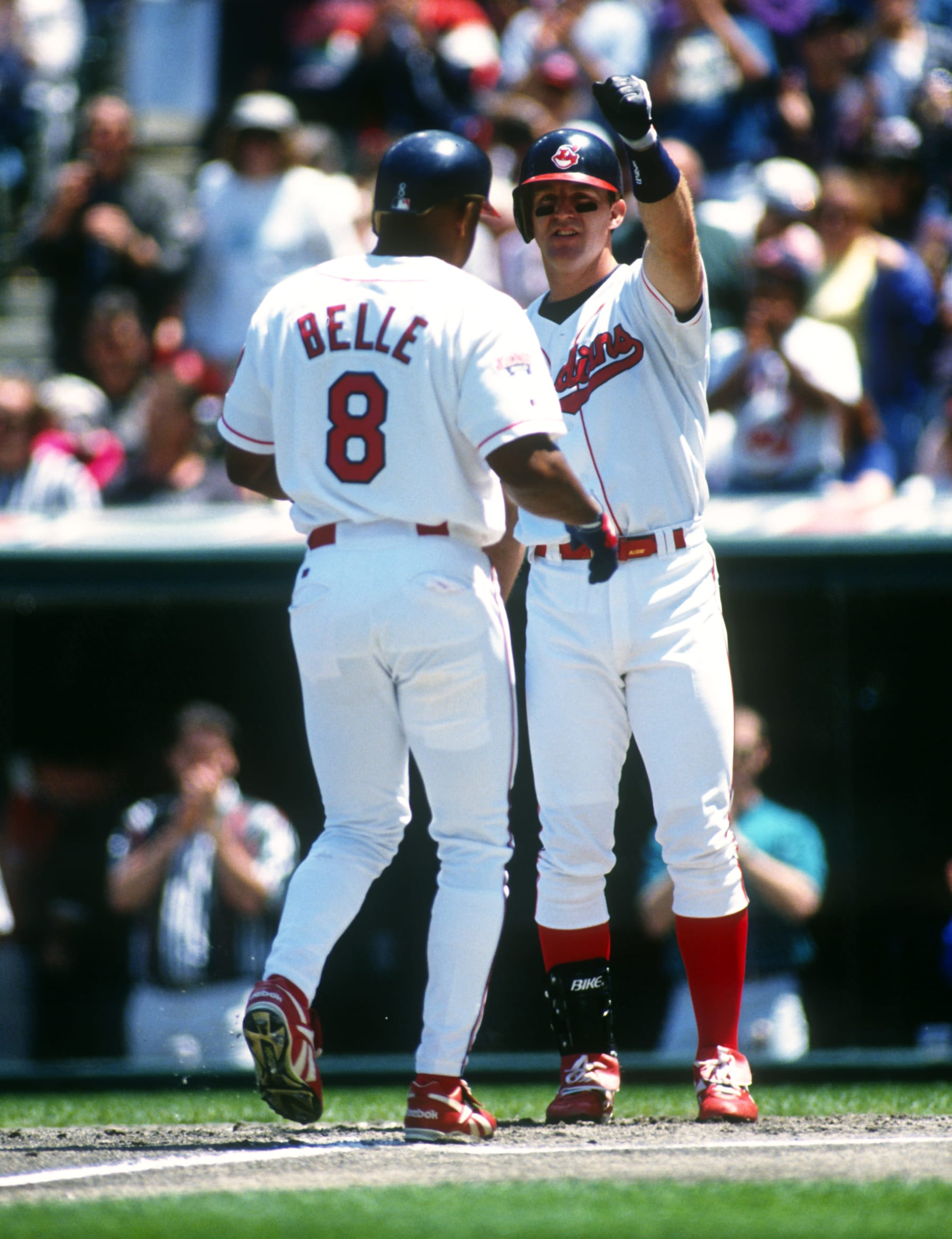 CLEVELAND - 1995: Jim Thome #25 greets Albert Belle #8 of the Cleveland Indians after Belle hit a home run in an MLB game at Jacobs Field in Cleveland, Ohio. Thome played for the Indians from 1991-2002. Belle played for the Indians from 1989-1996. (Photo by Ron Vesely/MLB Photos via Getty Images) 