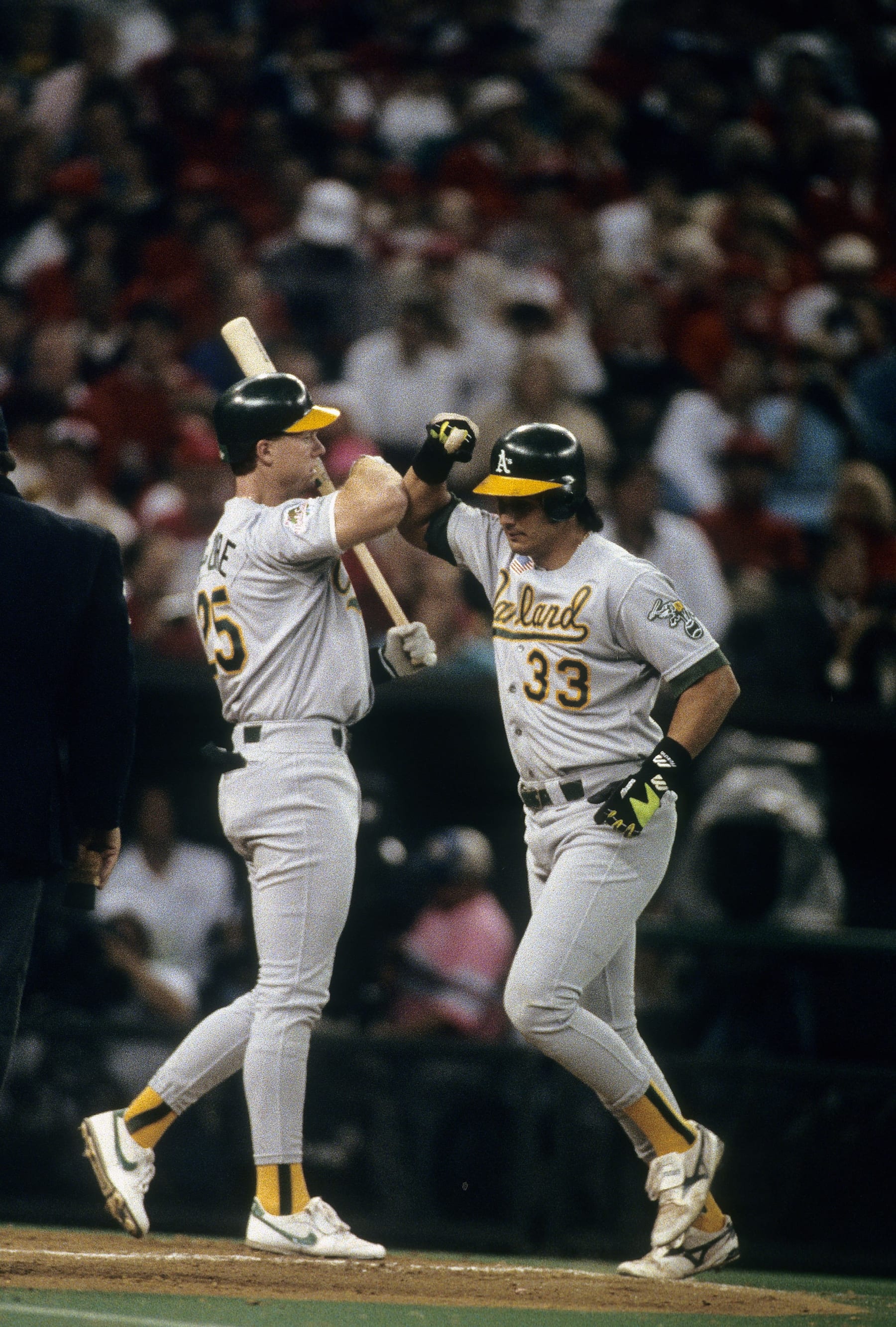 SAN FRANCISCO, CA - OCTOBER 27, 1989: Outfielder Jose Canseco #33 of the Oakland Athletics rounding the bases after hitting a home run, bashes forearms at home plate with teammate Mark McGwire #25 during game three of the 1989 World Series, October 27, 1989 at Candlestick Park in San Francisco, California. The Athletics swept the Giants 4-0. (Photo by Focus on Sport/Getty Images)