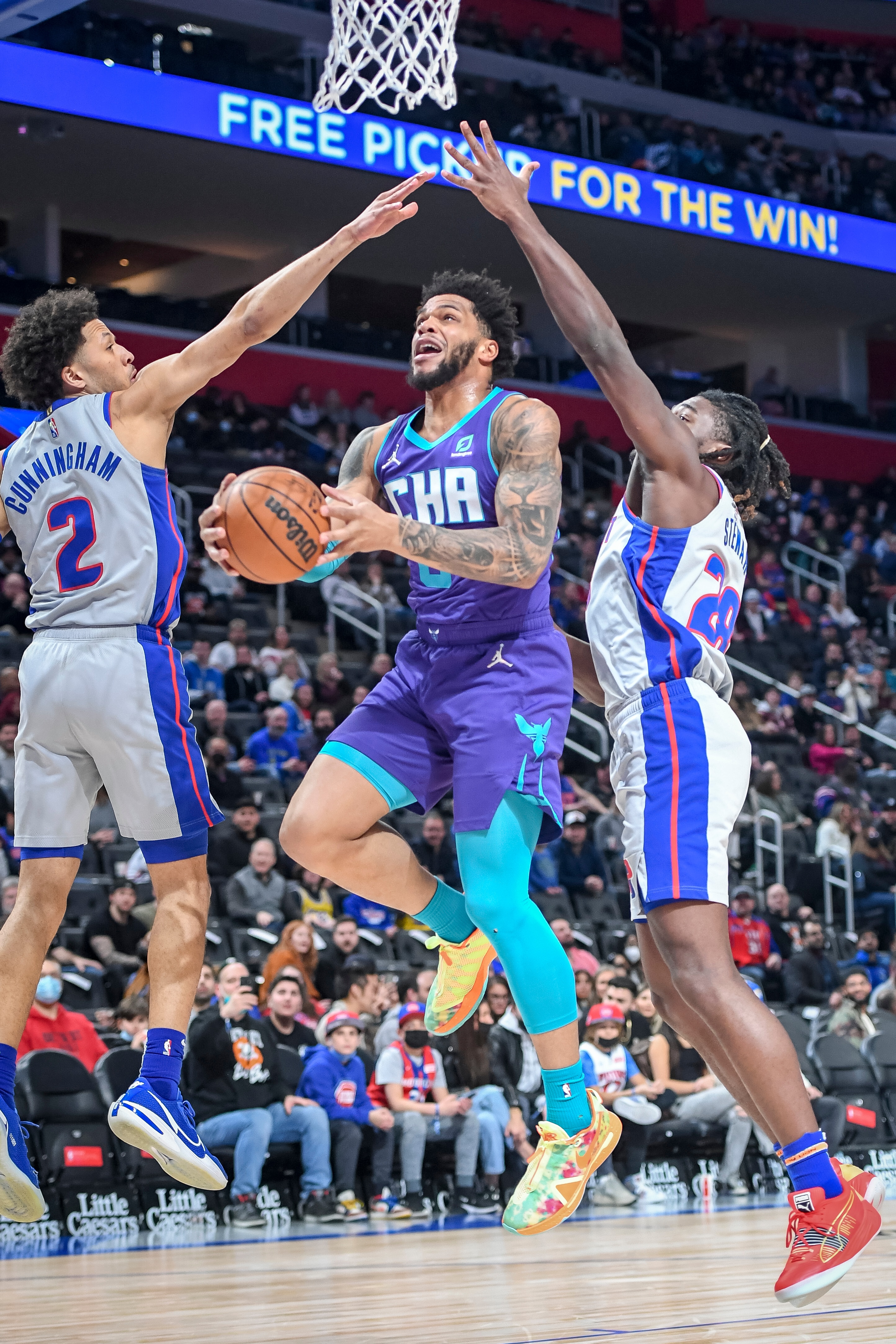 DETROIT, MICHIGAN - FEBRUARY 11: Miles Bridges #0 of the Charlotte Hornets shoots the ball against Cade Cunningham #2 and Isaiah Stewart #28 of the Detroit Pistons during the first quarter at Little Caesars Arena on February 11, 2022 in Detroit, Michigan. NOTE TO USER: User expressly acknowledges and agrees that, by downloading and or using this photograph, User is consenting to the terms and conditions of the Getty Images License Agreement. (Photo by Nic Antaya/Getty Images