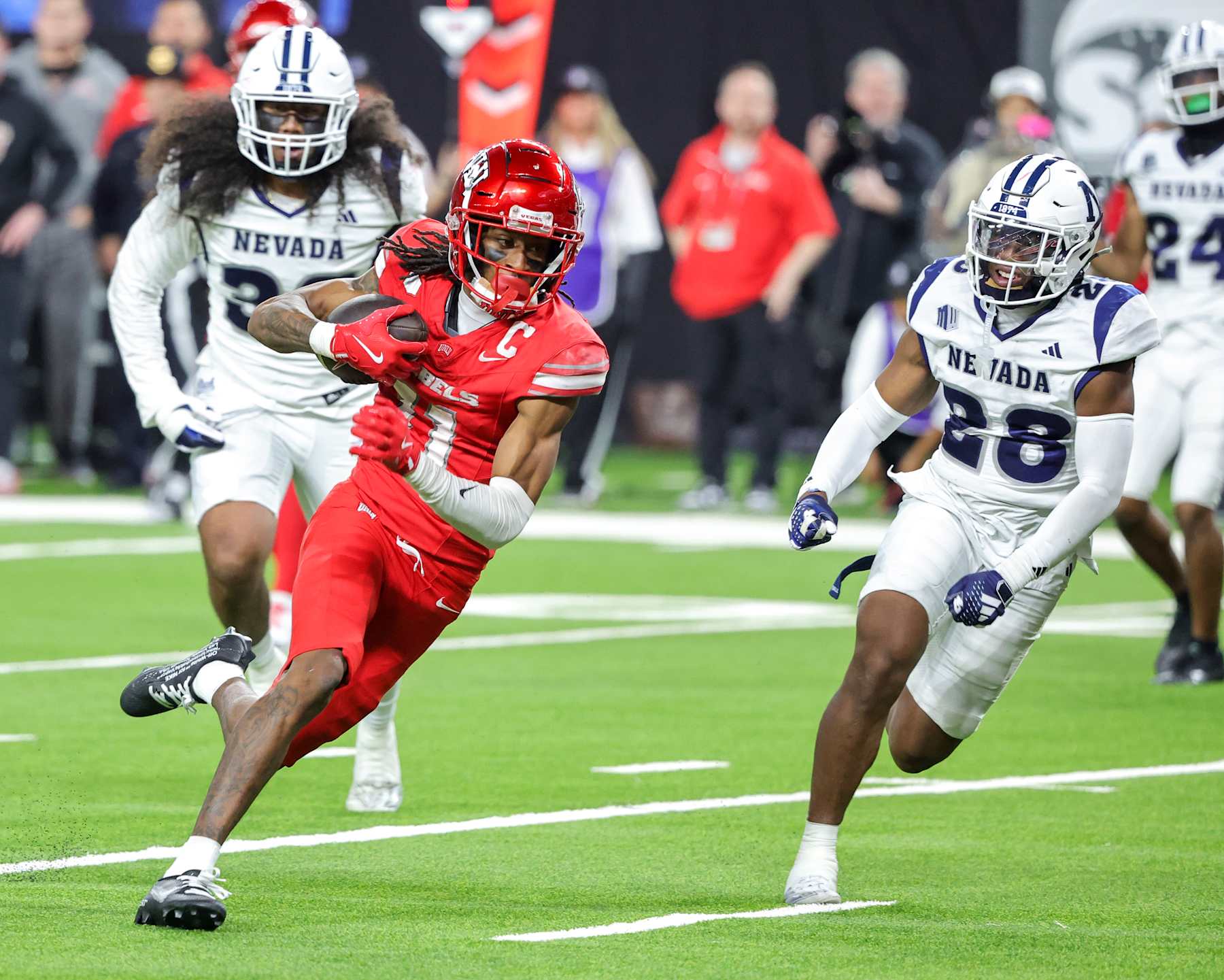 LAS VEGAS, NEVADA - NOVEMBER 30: Wide receiver Ricky White III #11 of the UNLV Rebels scores a touchdown against linebacker Tongiaki Mateialona #36 and defensive back Tori Daffin #28 of the Nevada Wolf Pack in the fourth quarter of their game at Allegiant Stadium on November 30, 2024 in Las Vegas, Nevada. The Rebels defeated the Wolf Pack 38-14. (Photo by Ethan Miller/Getty Images)