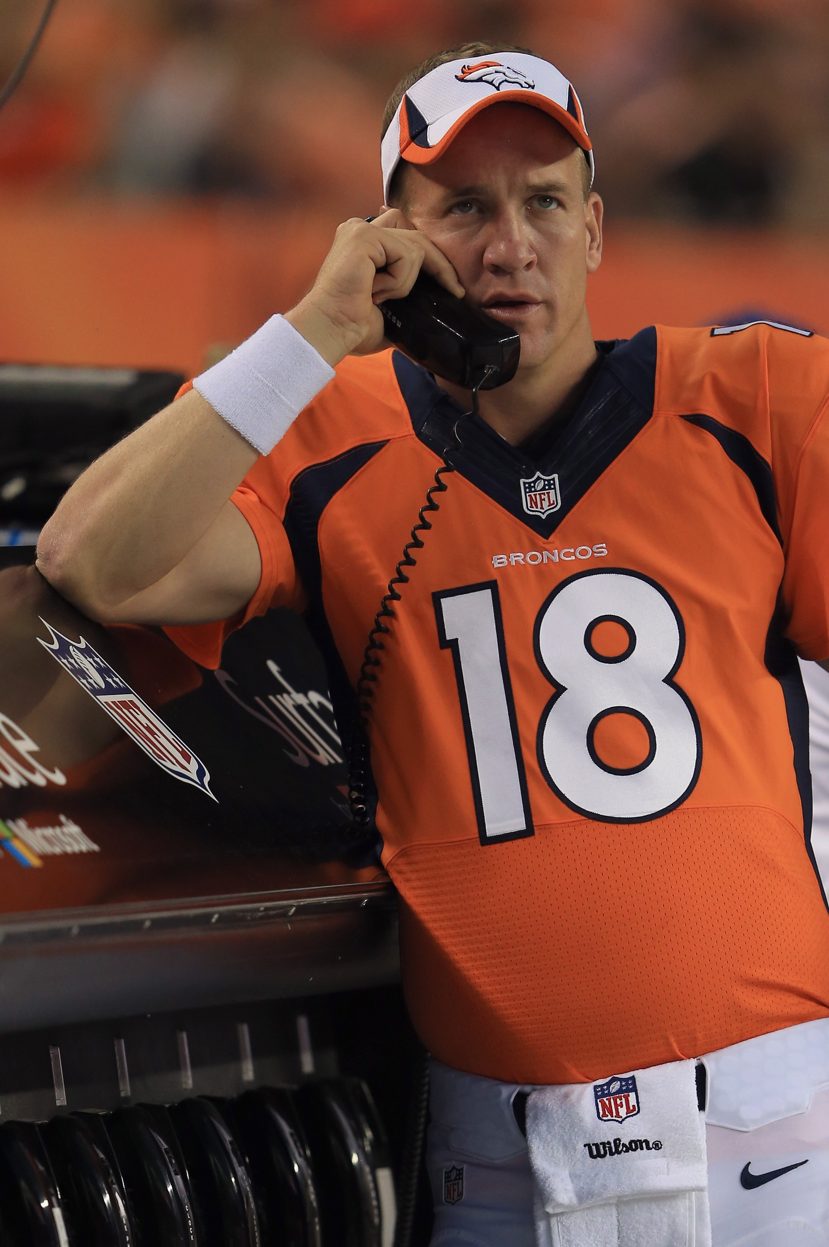 DENVER, CO - AUGUST 29:  Quarterback Peyton Manning #18 of the Denver Broncos talks on the phone on the sideline against the Arizona Cardinals during preseason action at Sports Authority Field at Mile High on August 29, 2013 in Denver, Colorado. The Cardinals defeated the Broncos 32-24.  (Photo by Doug Pensinger/Getty Images) 