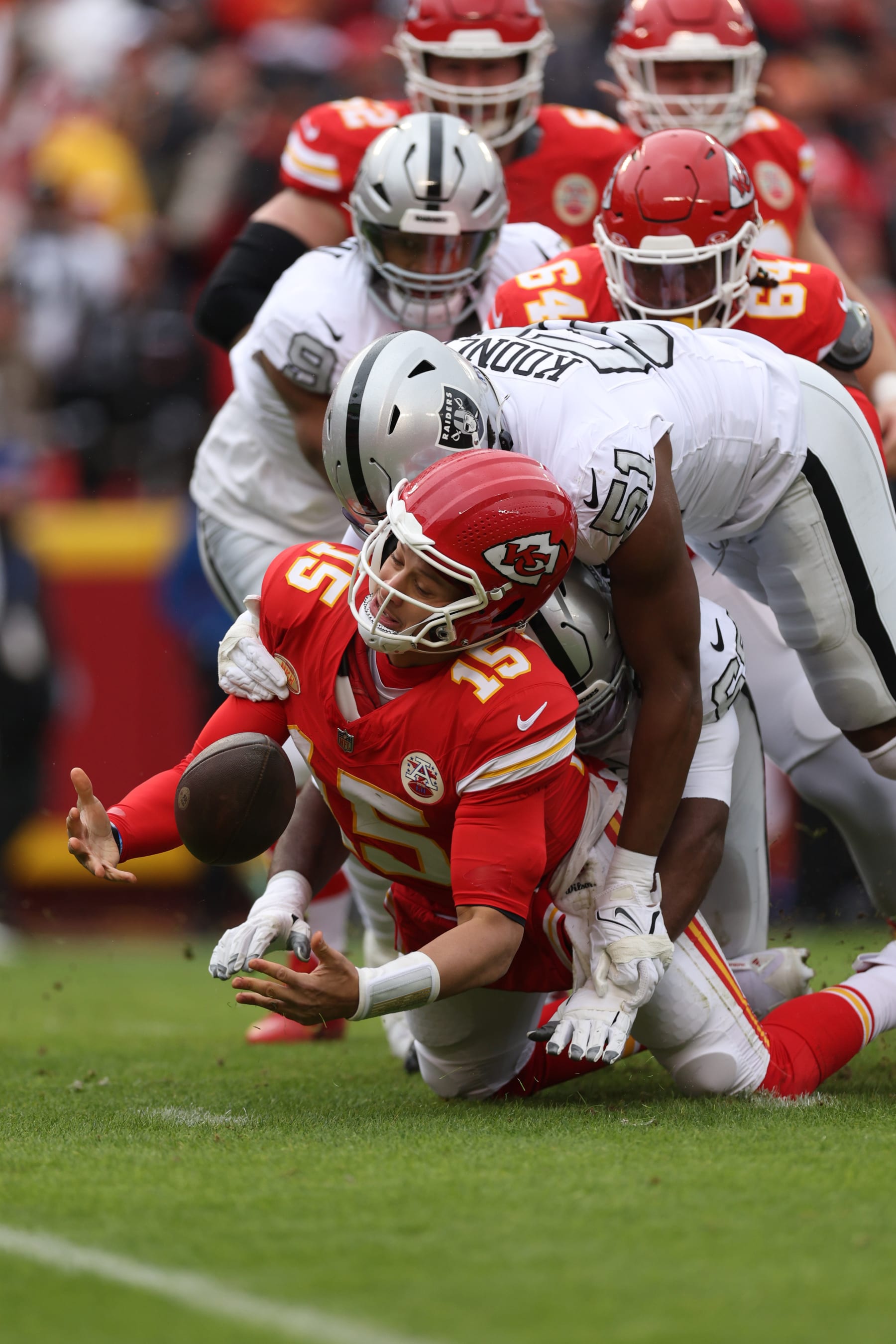 KANSAS CITY, MISSOURI - DECEMBER 25: Patrick Mahomes #15 of the Kansas City Chiefs recovers the ball as he is tackled by Malcolm Koonce #51 of the Las Vegas Raiders during the first quarter at GEHA Field at Arrowhead Stadium on December 25, 2023 in Kansas City, Missouri. (Photo by Jamie Squire/Getty Images)