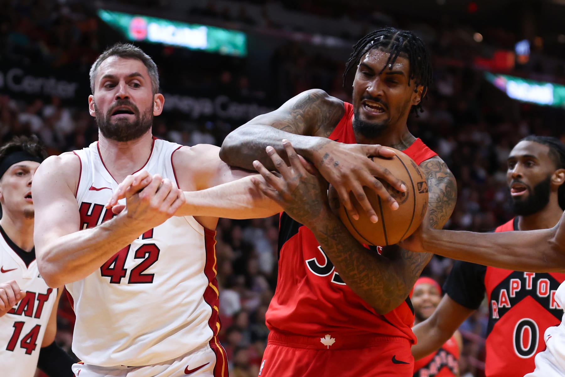 MIAMI, FLORIDA - APRIL 12: Christian Koloko #35 of the Toronto Raptors rebounds the ball against Kevin Love #42 of the Miami Heat during the third quarter of the game at Kaseya Center on April 12, 2024 in Miami, Florida. NOTE TO USER: User expressly acknowledges and agrees that, by downloading and or using this photograph, User is consenting to the terms and conditions of the Getty Images License Agreement. (Photo by Megan Briggs/Getty Images)