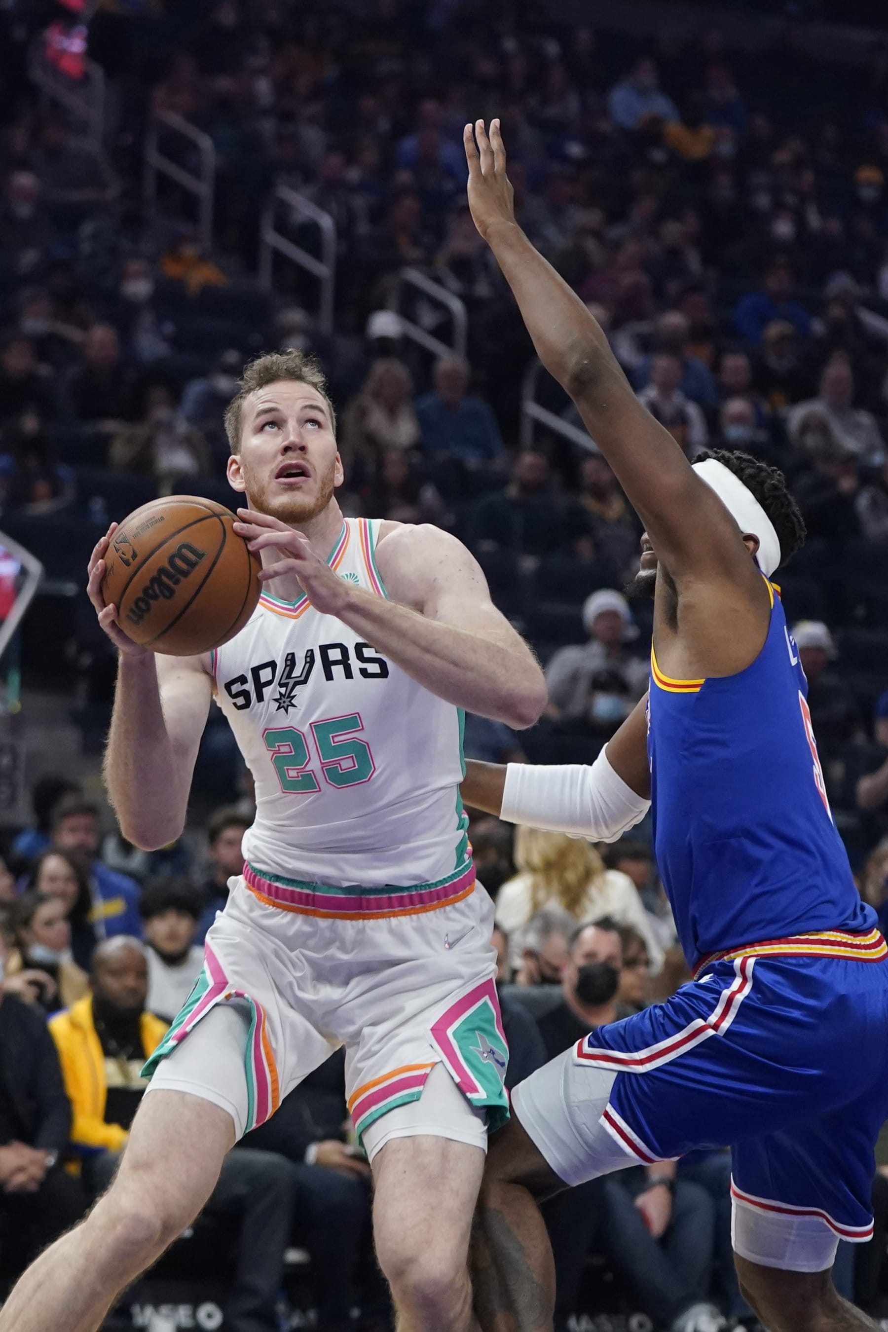 San Antonio Spurs center Jakob Poeltl (25) shoots against Golden State Warriors center Kevon Looney during an NBA basketball game in San Francisco, Saturday, Dec. 4, 2021. (AP Photo/Jeff Chiu)