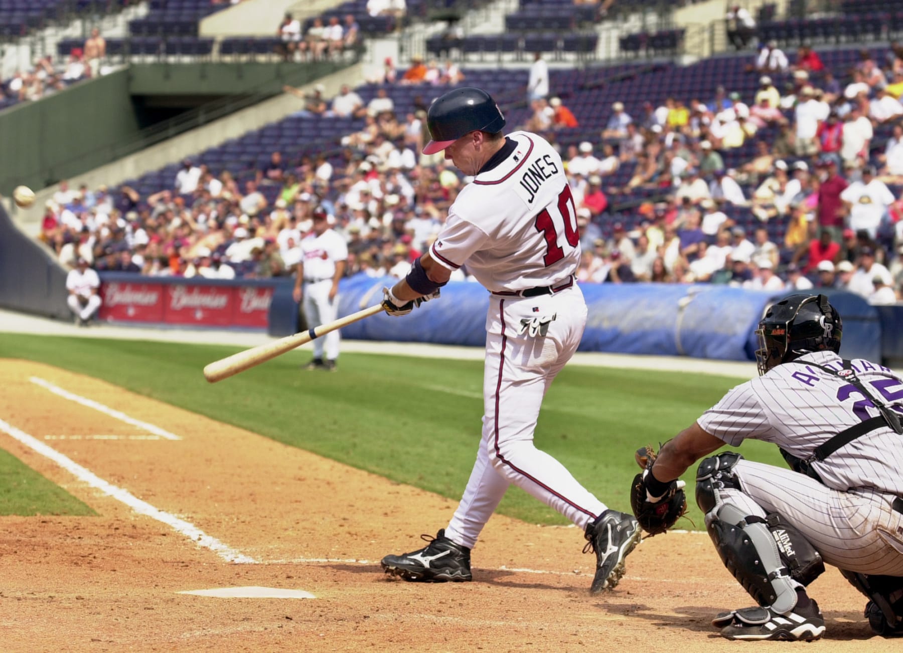 Atlanta Braves' Chipper Jones, left, hits a game-winning home run off Colorado Rockies reliever Jose Jimenez as catcher Sandy Alomar Jr., looks on in the ninth inning on Monday, Aug. 19, 2002, at Turner Field in Atlanta. The Braves beat the Rockies 7-6. (AP Photo/Erik S. Lesser)