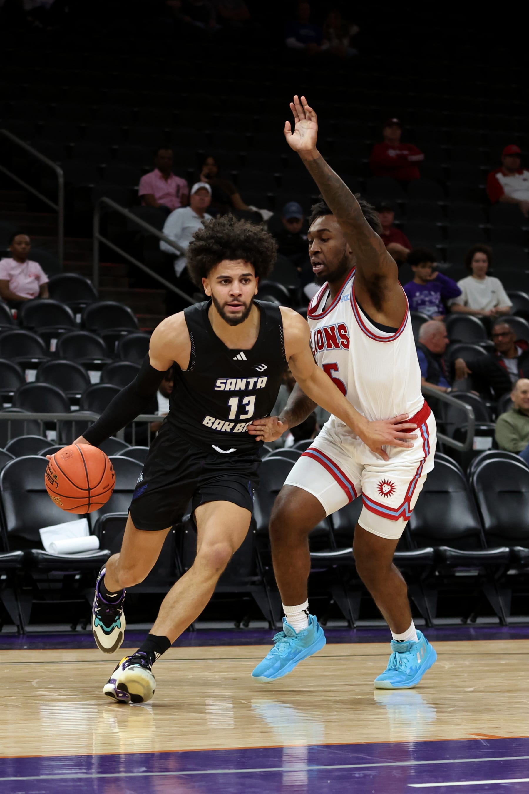 PHOENIX, AZ - DECEMBER 16: UC Santa Barbara Gauchos guard Ajay Mitchell (13) drives to the net against Loyola Marymount Lions guard Justin Wright (5) during the first half of a basketball game between the UC Santa Barbara Gauchos and the Loyola Marymount Lions at the Jerry Colangelo Classic on December 16, 2023, at Footprint Center in Phoenix, AZ. (Photo by Zac BonDurant/Icon Sportswire via Getty Images)