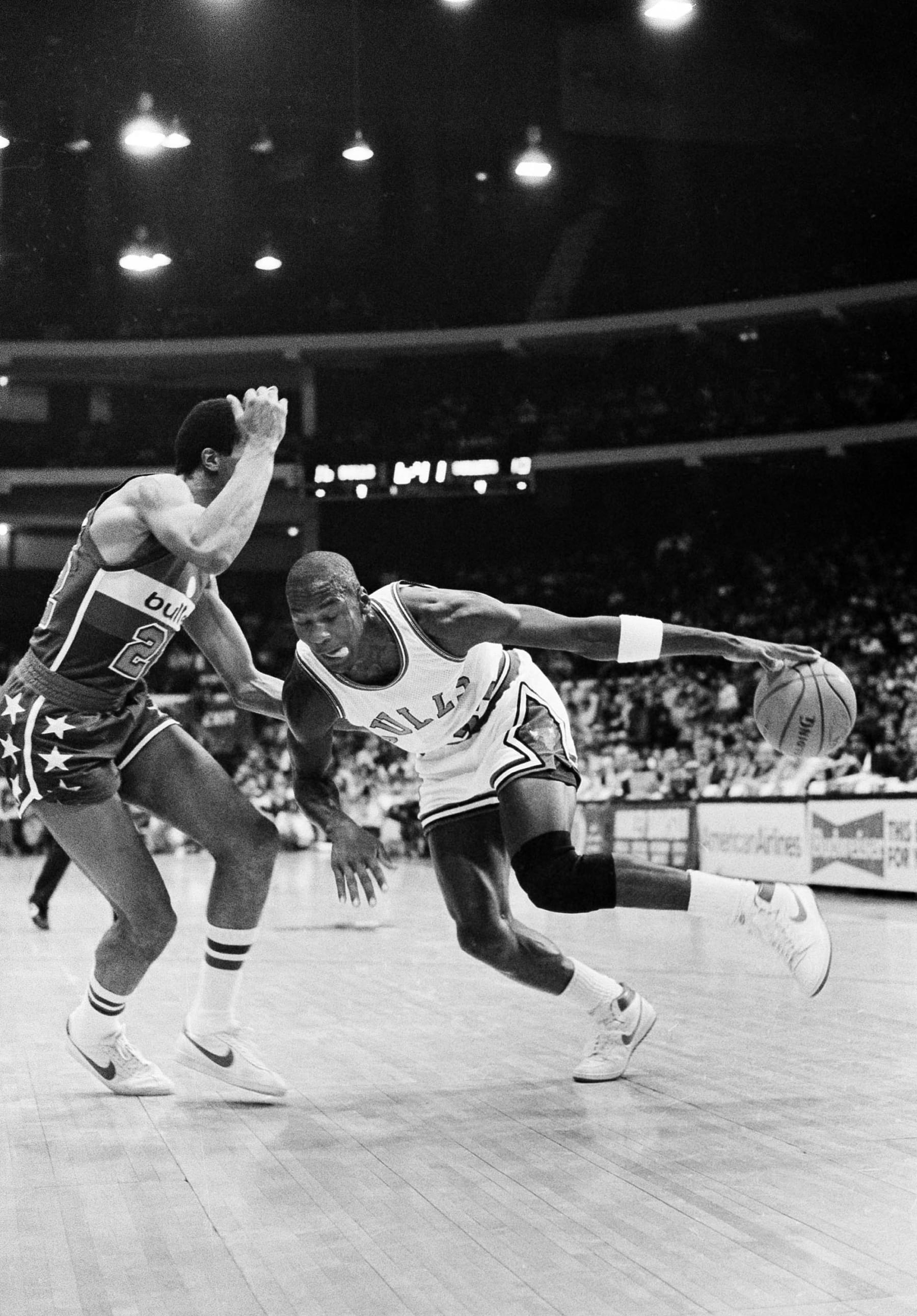Chicago Bulls' Michael Jordan drives past Washington Bullets' Dudley Bradley during NBA action in Chicago, Oct. 26, 1984. It was Jordan's debut in the regular NBA season. (AP Photo/Fred Jewell)