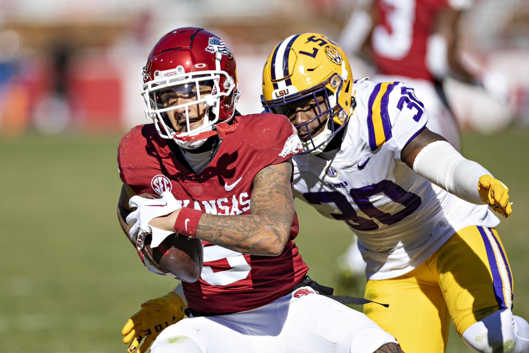 FAYETTEVILLE, ARKANSAS - NOVEMBER 12: Jadon Haselwood #9 of the Arkansas Razorbacks catches a pass and is tackled by Greg Penn III #30 of the LSU Tigers at Donald W. Reynolds Razorback Stadium on November 12, 2022 in Fayetteville, Arkansas. The Tigers defeated the Razorbacks 13-10. (Photo by Wesley Hitt/Getty Images)