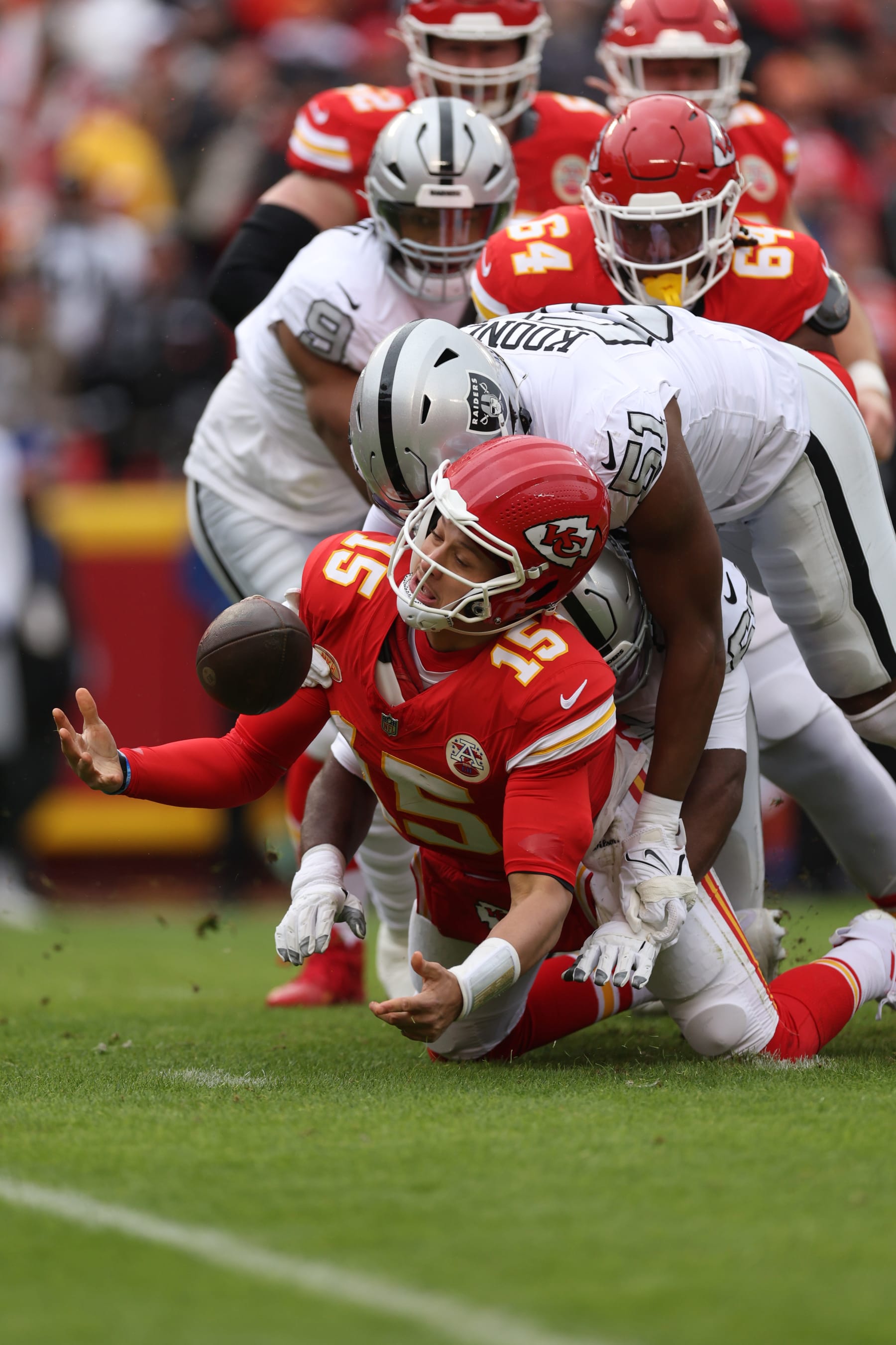 KANSAS CITY, MISSOURI - DECEMBER 25: Patrick Mahomes #15 of the Kansas City Chiefs recovers the ball as he is tackled by Malcolm Koonce #51 of the Las Vegas Raiders during the first quarter at GEHA Field at Arrowhead Stadium on December 25, 2023 in Kansas City, Missouri. (Photo by Jamie Squire/Getty Images)