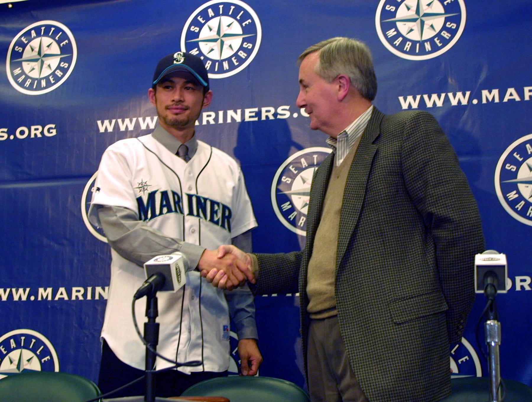 New Seattle Mariner Ichiro Suzuki (L) is welcomed by team CEO Howard Lincoln (R) during a press conference in Seattle, Washington, 30 November, 2000. Suzuki signed a three-year contract to play with the club.   AFP PHOTO/DAN LEVINE (Photo by DAN LEVINE / AFP) (Photo by DAN LEVINE/AFP via Getty Images)