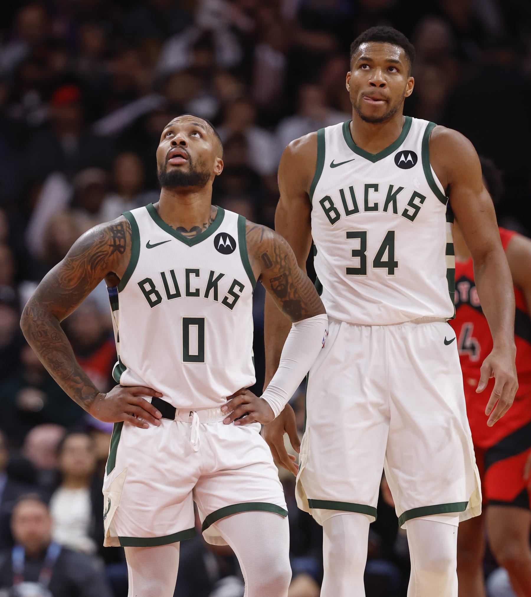 TORONTO, ON - NOVEMBER 1: Milwaukee Bucks guard Damian Lillard (0) and Milwaukee Bucks forward Giannis Antetokounmpo (34) look to the scoreboard after a play and stop in action. Toronto Raptors vs Milwaukee Bucks during 2nd half action of NBA regular season play at Scotiabank Arena. Raptors won 130-111. Toronto Star
        (Rick Madonik/Toronto Star via Getty Images)