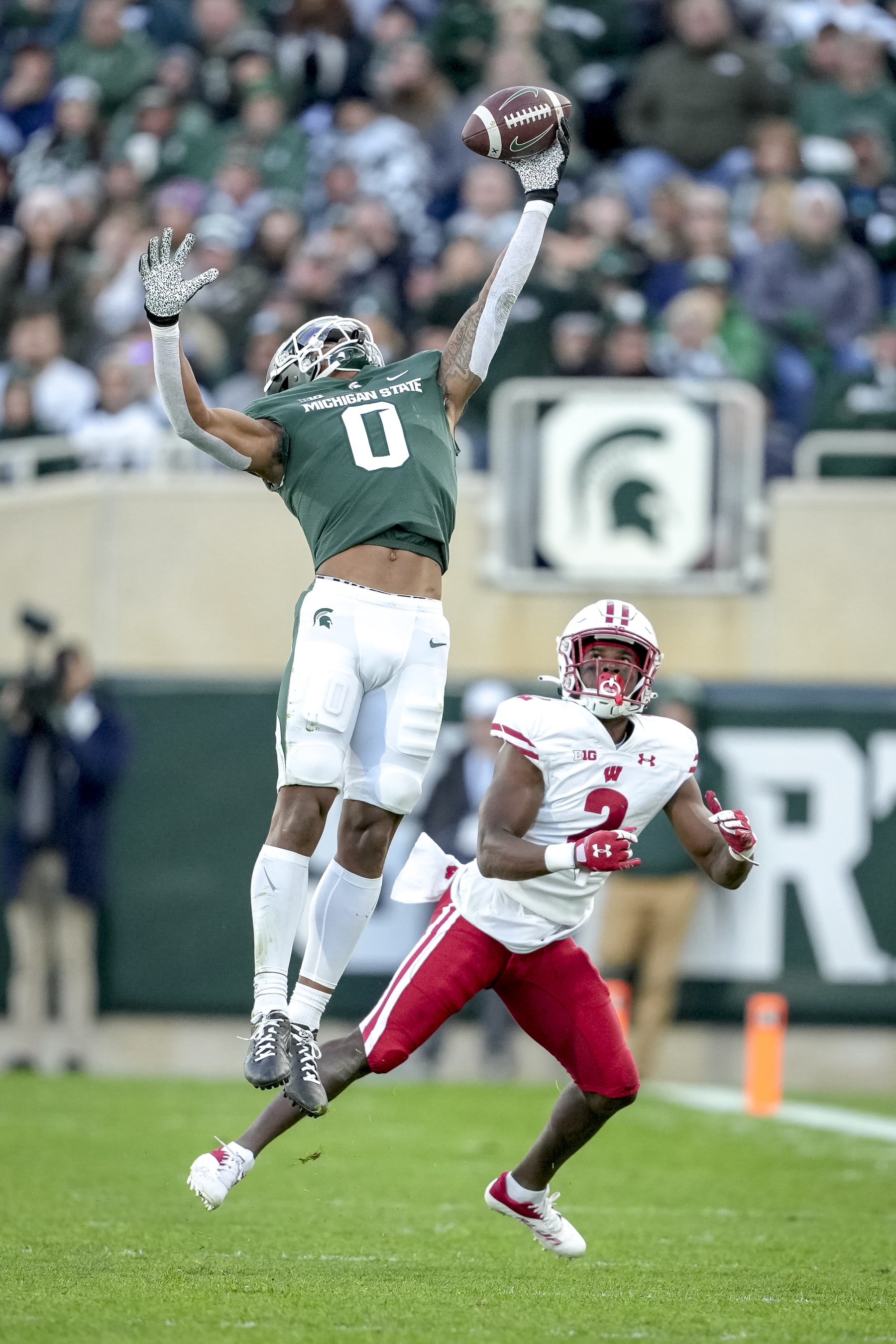 EAST LANSING, MICHIGAN - OCTOBER 15: Keon Coleman #0 of the Michigan State Spartans tips a pass against Ricardo Hallman #2 of the Wisconsin Badgers during the third quarter at Spartan Stadium on October 15, 2022 in East Lansing, Michigan. (Photo by Nic Antaya/Getty Images)