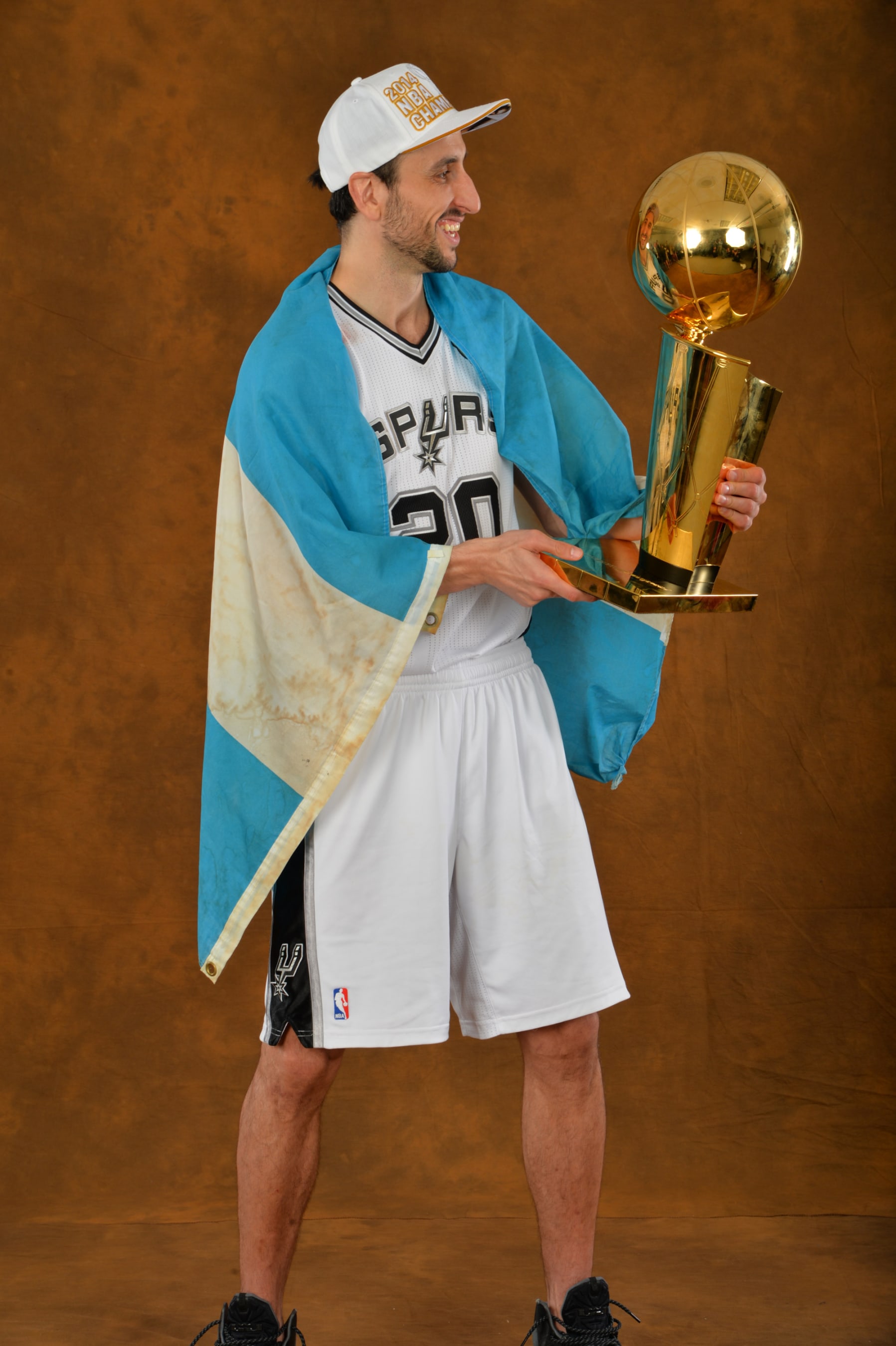 SAN ANTONIO, TX - JUNE 15: Manu Ginobili #20 of the San Antonio Spurs poses for a portrait with the Larry O'Brien Trophy after defeating the Miami Heat in Game Five of the 2014 NBA Finals on June 15, 2014 at AT&T Center in San Antonio, Texas. NOTE TO USER: User expressly acknowledges and agrees that, by downloading and or using this photograph, User is consenting to the terms and conditions of the Getty Images License Agreement. Mandatory Copyright Notice: Copyright 2014 NBAE (Photo by Jesse D. Garrabrant/NBAE via Getty Images)