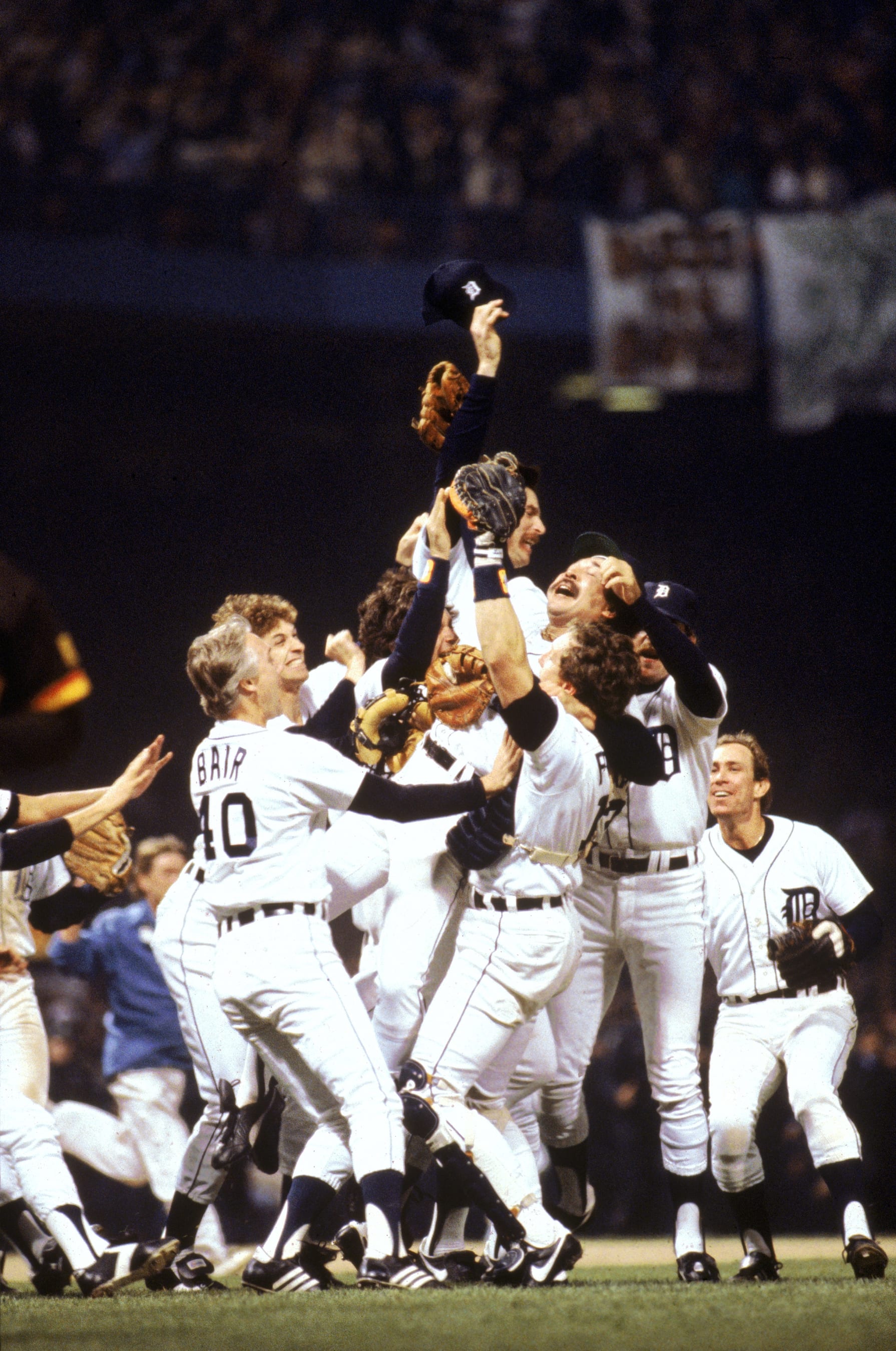 DETROIT - OCTOBER 14:  Catcher Lance Parrish #13 of the Detroit Tigers holds up teammate pitcher Wille Hernandez #21 as the Tigers celebrate on the field after winning game 5 of the 1984 World Series against the San Diego Padres at Tiger Stadium on October 14, 1984 in Detroit, Michigan. The Tigers won 4 games to 1. Alan Trammell was the series MVP. (Photo by Rich Pilling/MLB Photos via Getty Images)