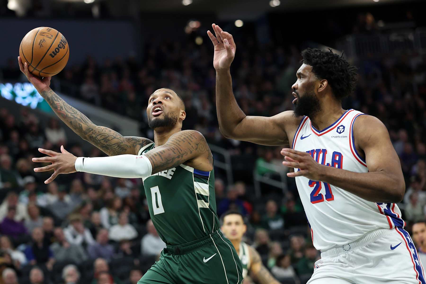 MILWAUKEE, WISCONSIN - FEBRUARY 09: Damian Lillard #0 of the Milwaukee Bucks drives to the basket against Joel Embiid #21 of the Philadelphia 76ers during the first half of a game at Fiserv Forum on February 09, 2025 in Milwaukee, Wisconsin. NOTE TO USER: User expressly acknowledges and agrees that, by downloading and or using this photograph, User is consenting to the terms and conditions of the Getty Images License Agreement. (Photo by Stacy Revere/Getty Images)