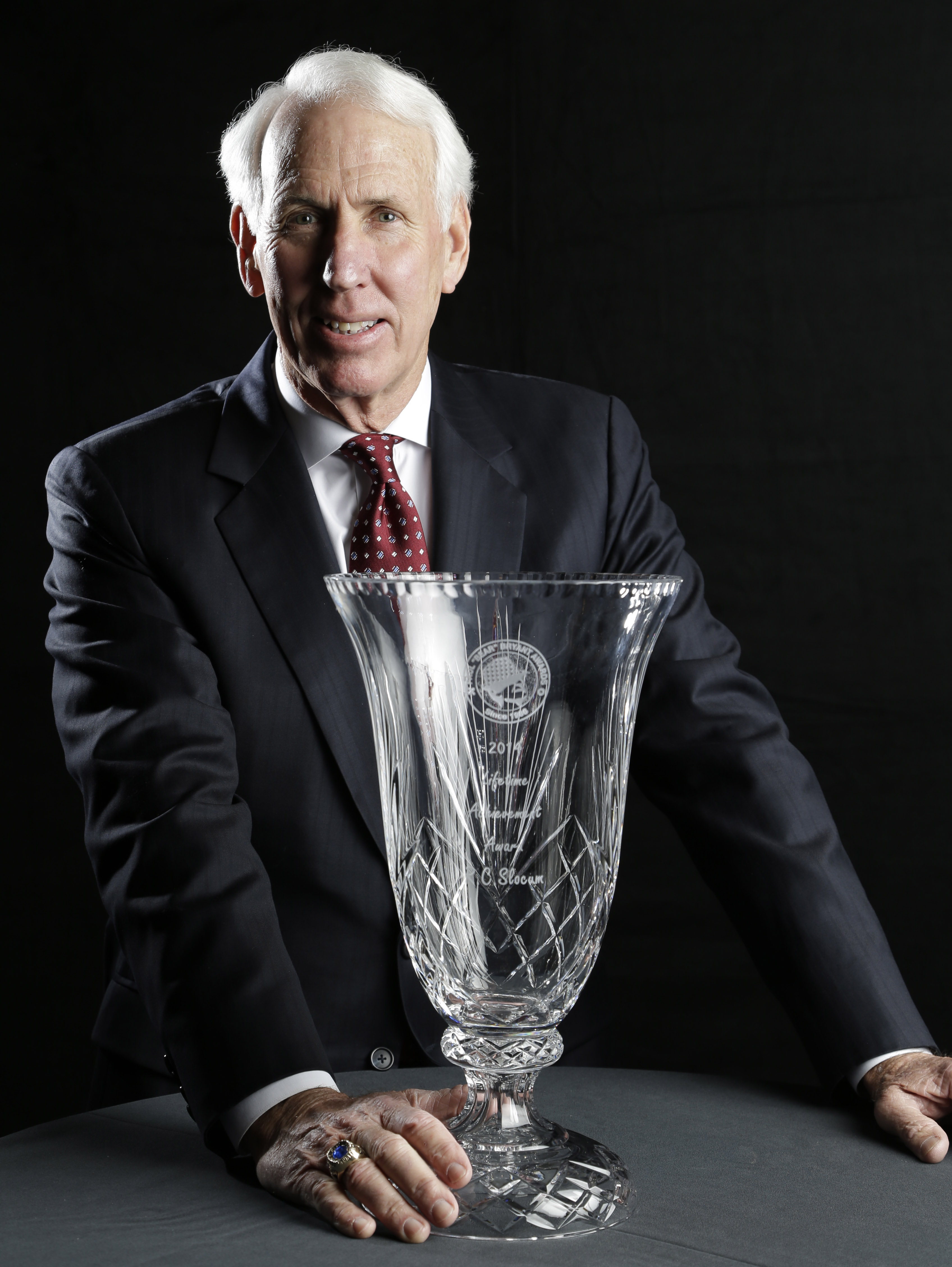 Former Texas A&M football coach R.C. Slocum, winner of the the Paul "Bear" Bryant Lifetime Achievement award, poses with his trophy Wednesday, Jan. 15, 2014, in Houston. (AP Photo/Pat Sullivan)