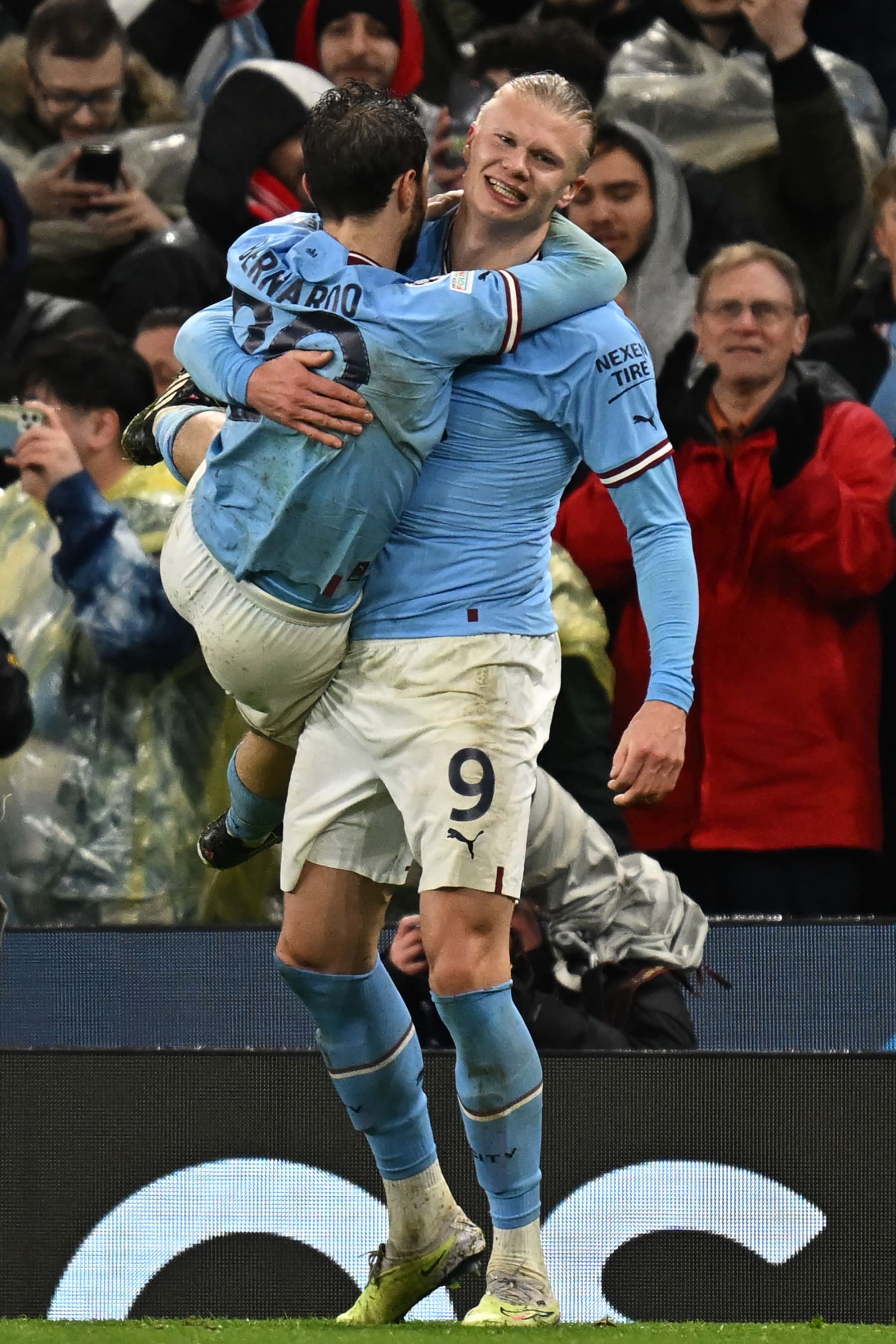 Manchester City's Norwegian striker Erling Haaland (R) celebrates with Manchester City's Portuguese midfielder Bernardo Silva (L) after scoring their third goal during the UEFA Champions League quarter final, first leg football match between Manchester City and Bayern Munich at the Etihad Stadium in Manchester, north-west England, on April 11, 2023. (Photo by Paul ELLIS / AFP) (Photo by PAUL ELLIS/AFP via Getty Images)