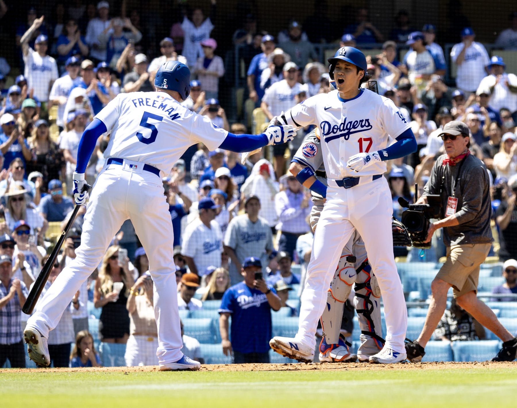 LOS ANGELES, CA - APRIL 21, 2024: Los Angeles Dodgers designated hitter player Shohei Ohtani (17) gets congrats from Los Angeles Dodgers first base Freddie Freeman (5) after hitting a  2-run homer against the New York Mets in the third inning  at Dodger Stadium  on April  21, 2024 in Los Angeles, California.(Gina Ferazzi / Los Angeles Times via Getty Images)