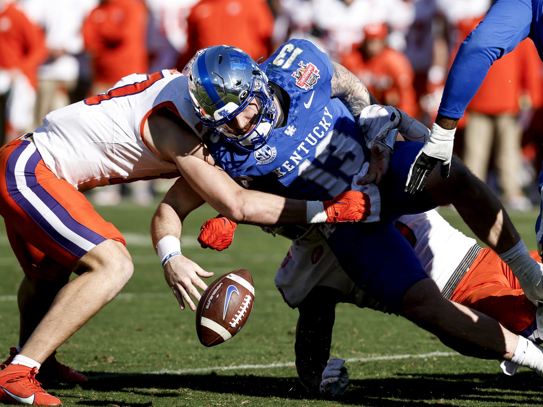 JACKSONVILLE, FL - DECEMBER 29: Quarterback Devin Leary #13 of the Kentucky Wildcats fumbles the ball while being tackled by Defensive End Xavier Thomas #3 and Linebacker Wade Woodaz #17 of the Clemson Tigers during the 79th annual TaxSlayer Gator Bowl game at EverBank Stadium on December 29, 2023 in Jacksonville, Florida. The Tigers defeated the Wildcats 38 to 35. (Photo by Don Juan Moore/Getty Images)