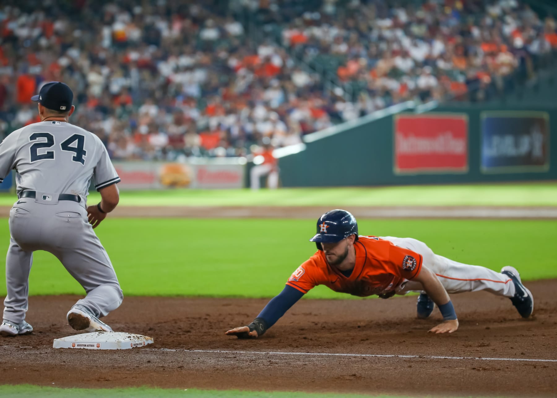 HOUSTON, TX - JULY 21:  Houston Astros right fielder Kyle Tucker (30) slides safely back to first base and avoids a tag b New York Yankees first baseman Matt Carpenter (24)in the bottom of the first inning during the MLB doubleheader Game 2 between the New York Yankees and Houston Astros on July 21, 2022 at Minute Maid Park in Houston, Texas.  (Photo by Leslie Plaza Johnson/Icon Sportswire via Getty Images)