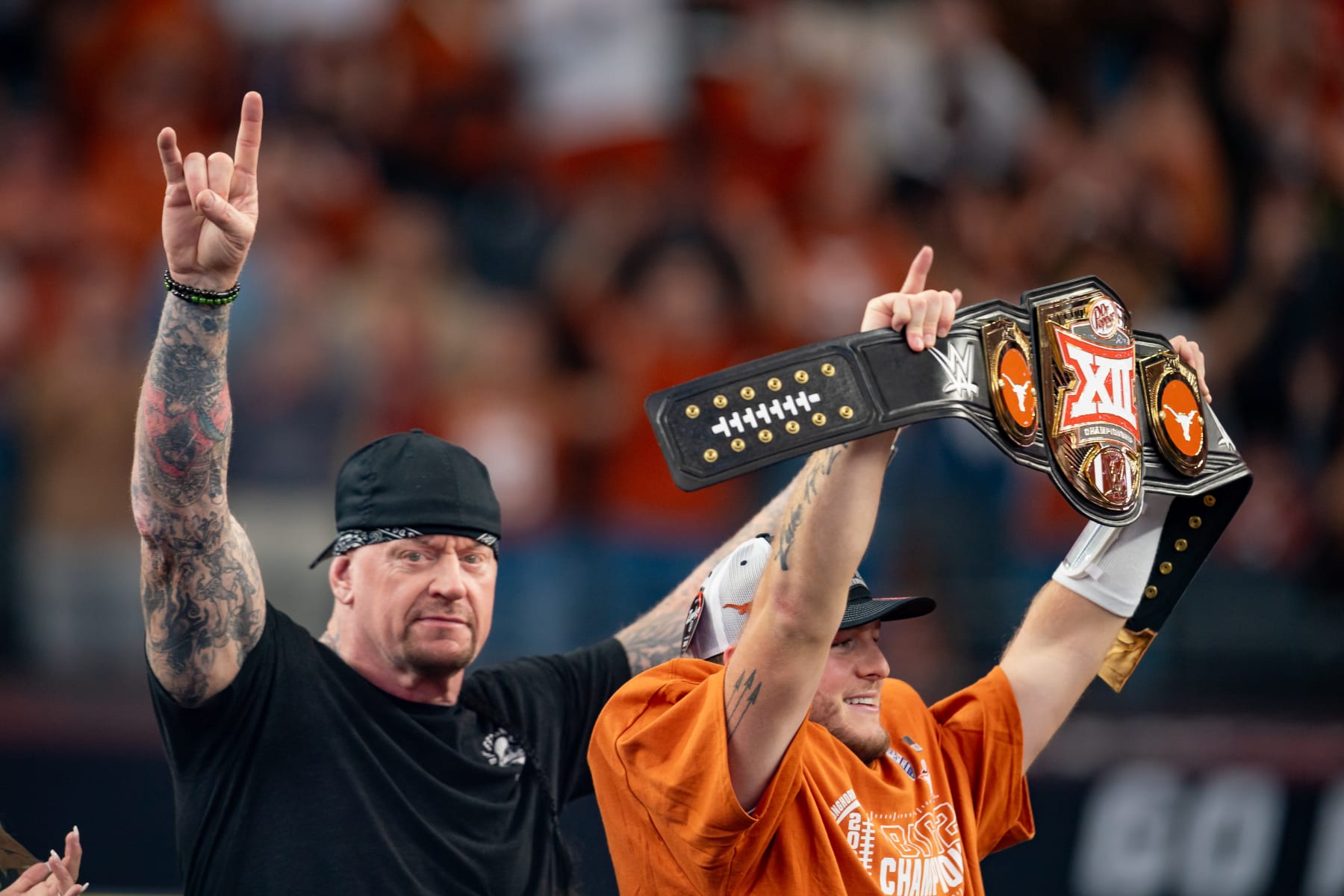 ARLINGTON, TX - DECEMBER 02: Texas Longhorns quarterback Quinn Ewers (3) holds up his belt as WWE Legend The Undertaker throws up horns after winning the Big 12 Championship game between the Texas Longhorns and the Oklahoma State Cowboys on December 02, 2023 at AT&T Stadium in Arlington, TX. (Photo by Chris Leduc/Icon Sportswire via Getty Images)