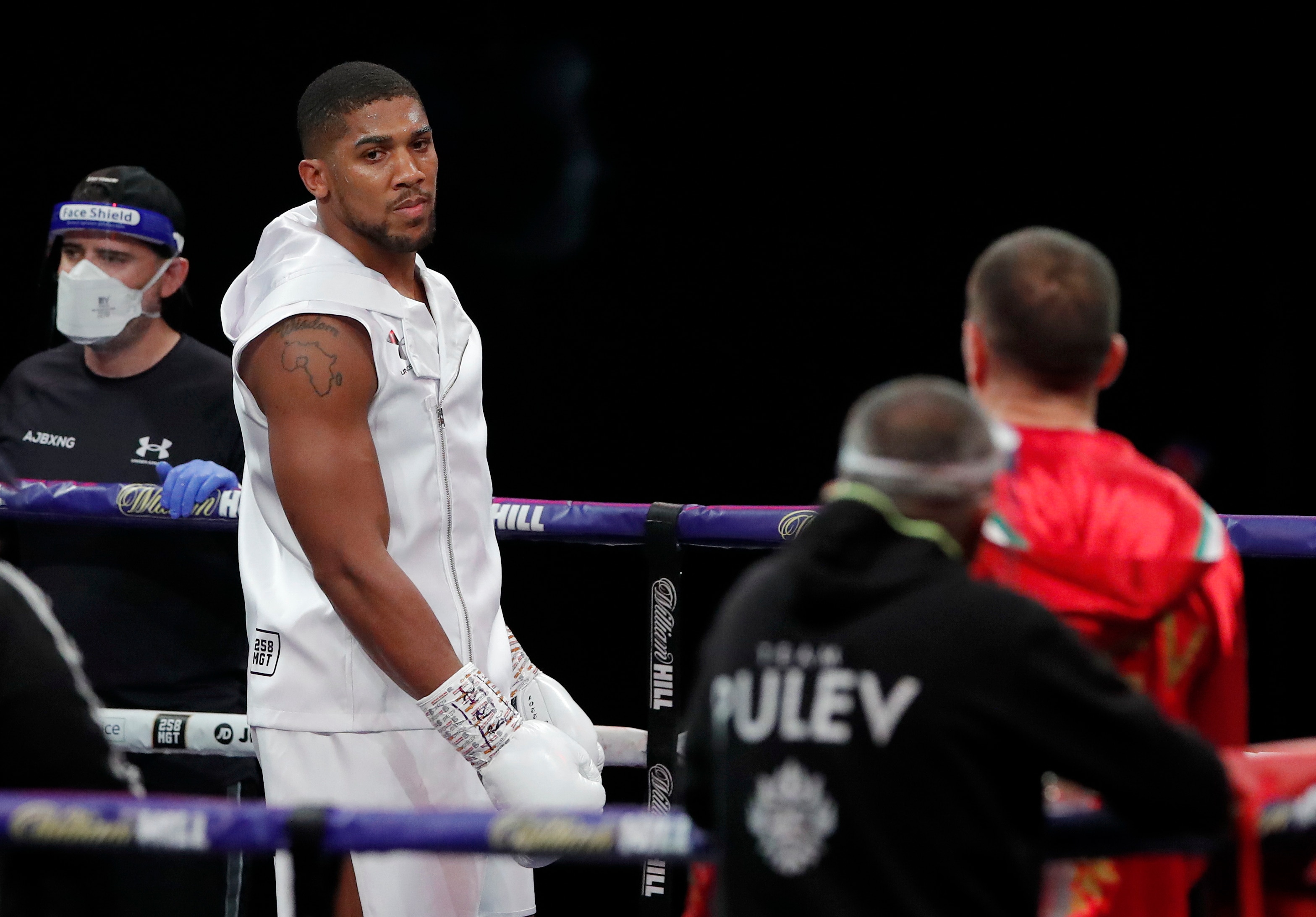 World Heavyweight boxing champion Britain's Anthony Joshua looks across at challenger Bulgaria's Kubrat Pulev before their Heavyweight title bout at Wembley Arena in London Saturday, Dec. 12, 2020. (Andrew Couldridge/Pool via AP)